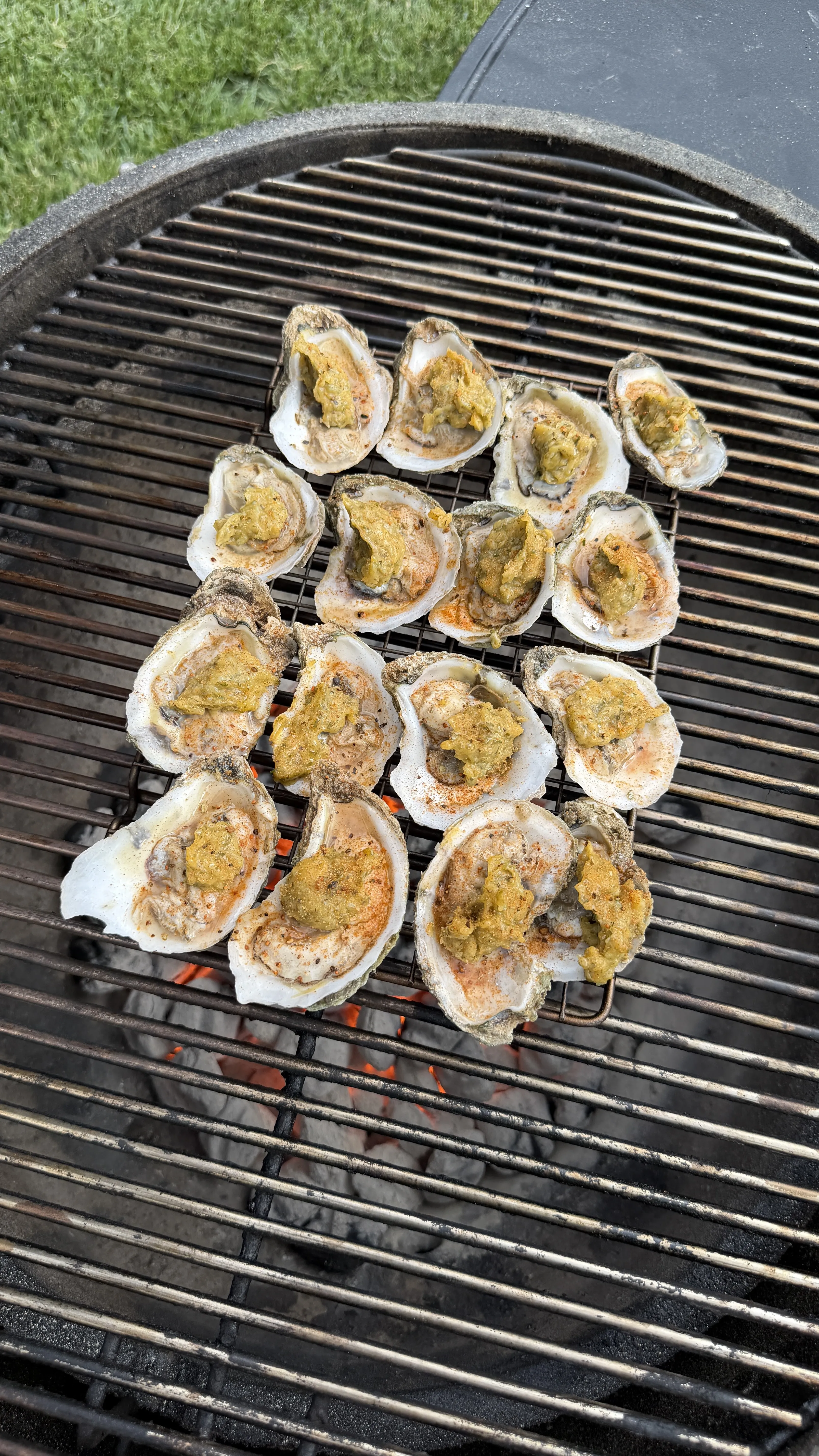 Grilled garlic herb parmesan oysters with melted bubbling cheese topping on barbecue