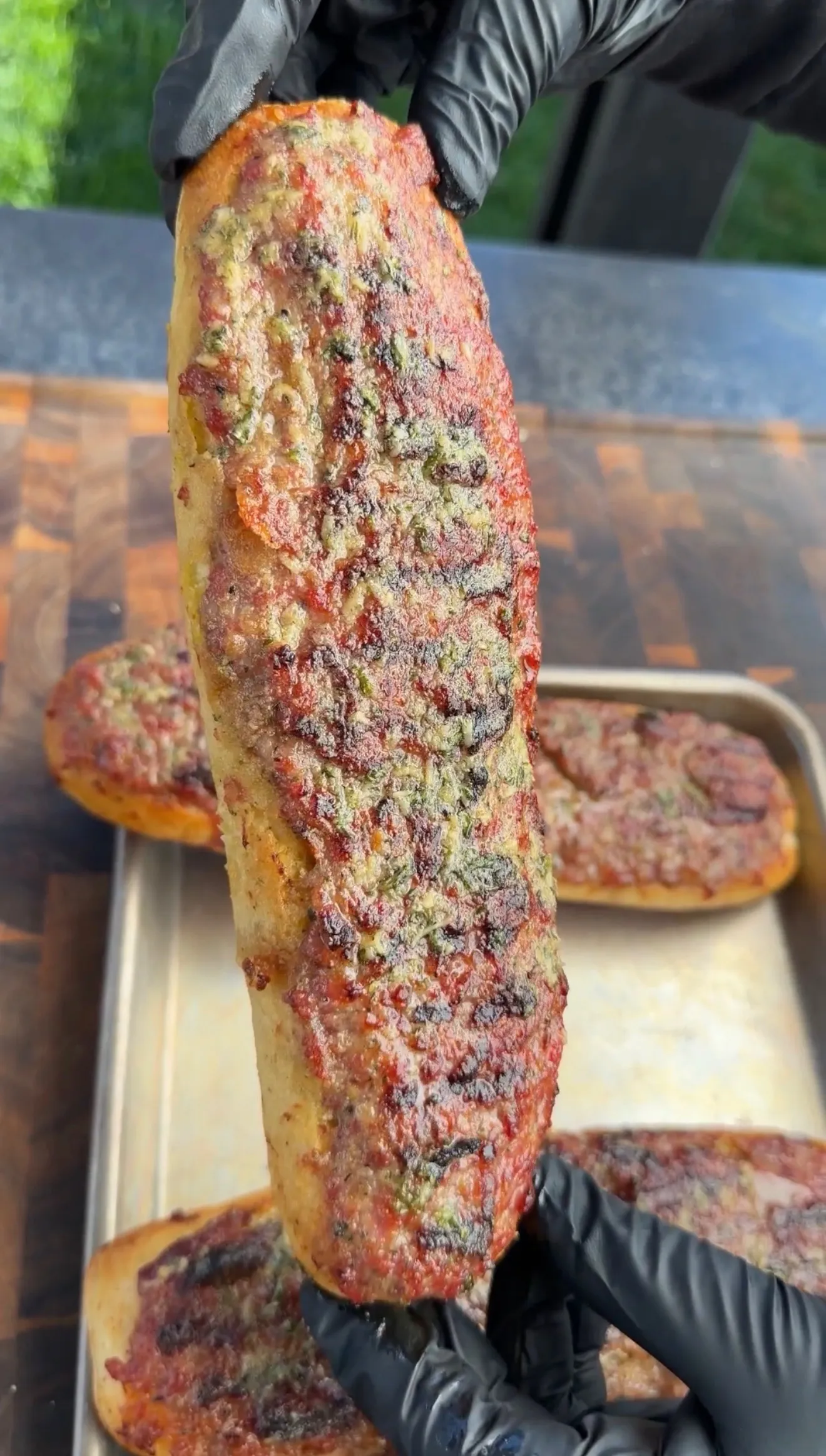 Grilled sausage stuffed bread boat being lifted