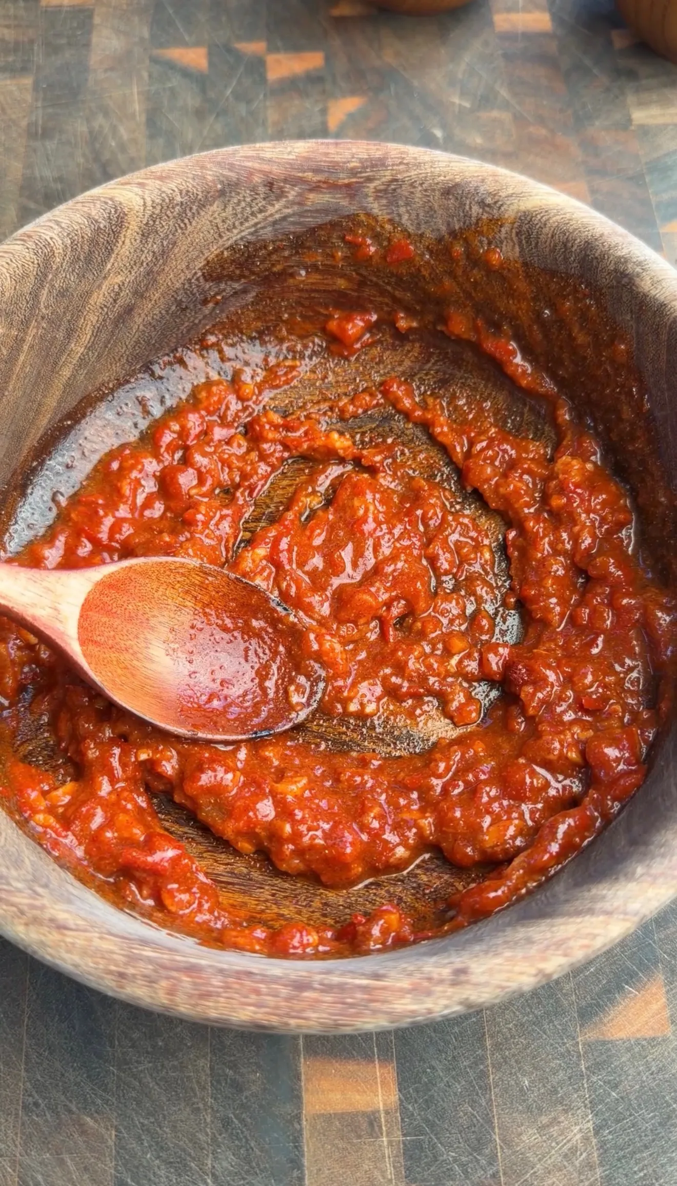 Homemade harissa paste in wooden bowl with spoon