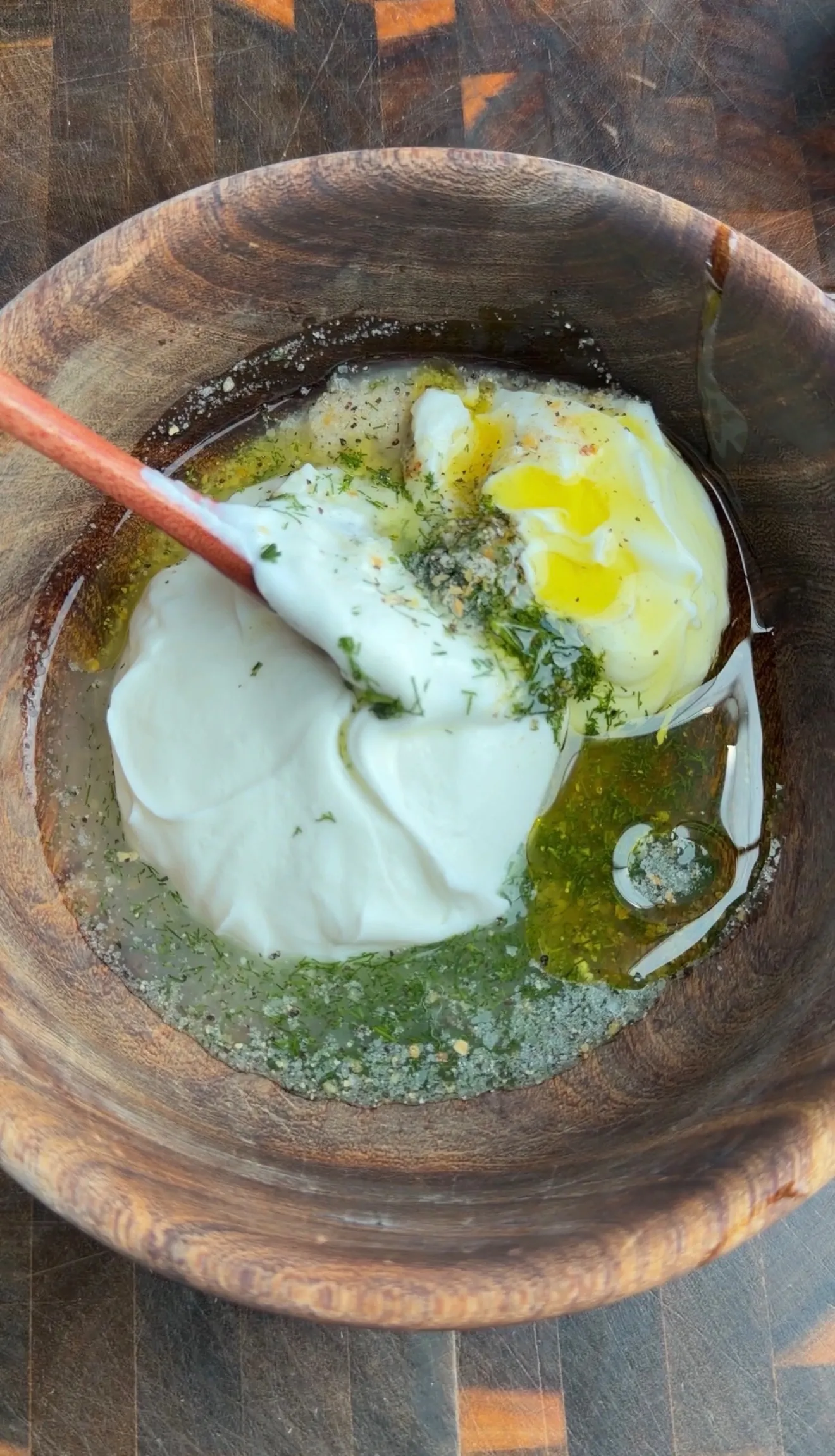 Homemade herb yogurt sauce ingredients in wooden bowl