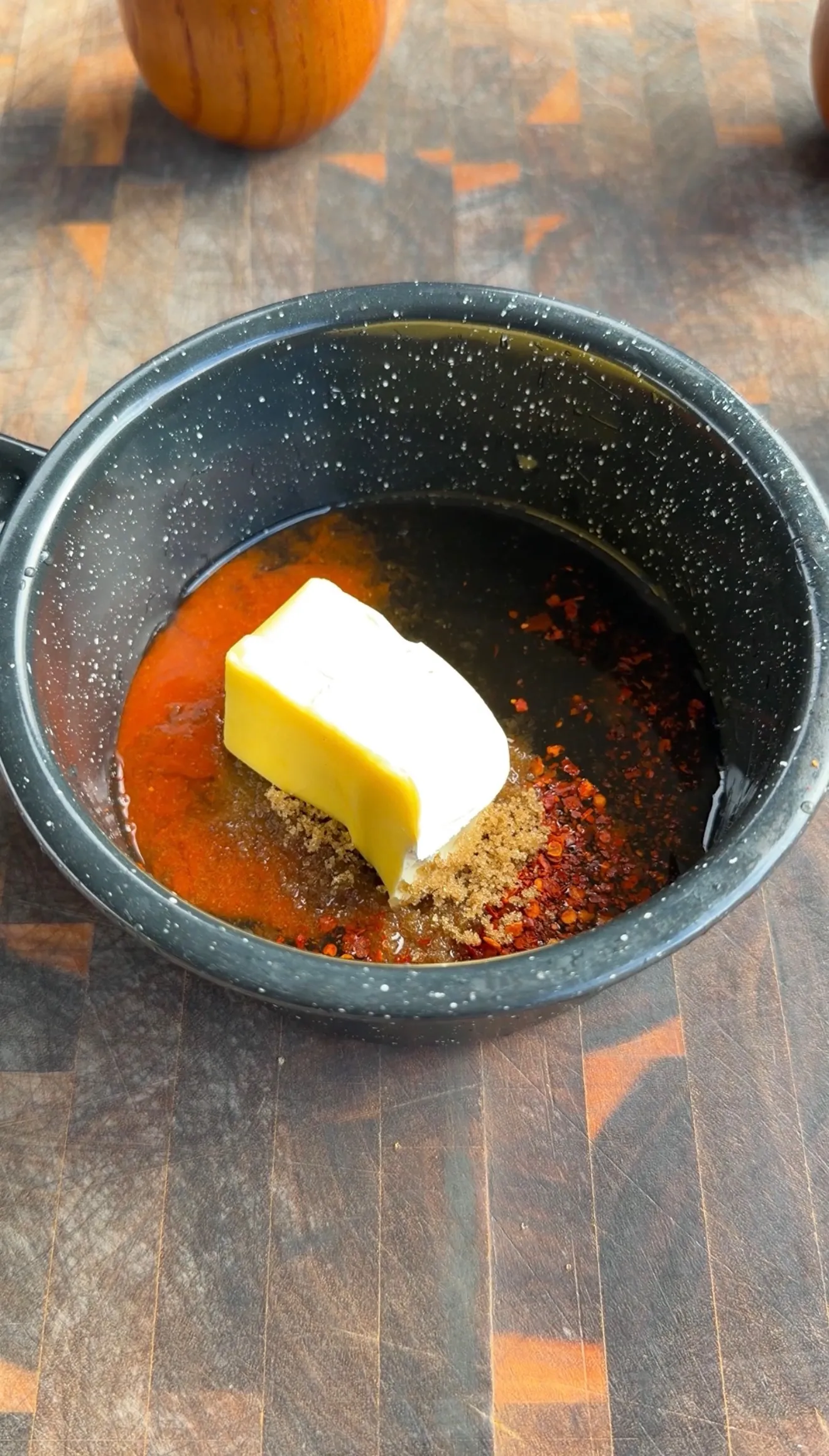 Butter melting with hot honey sauce ingredients in a cast iron pan over heat