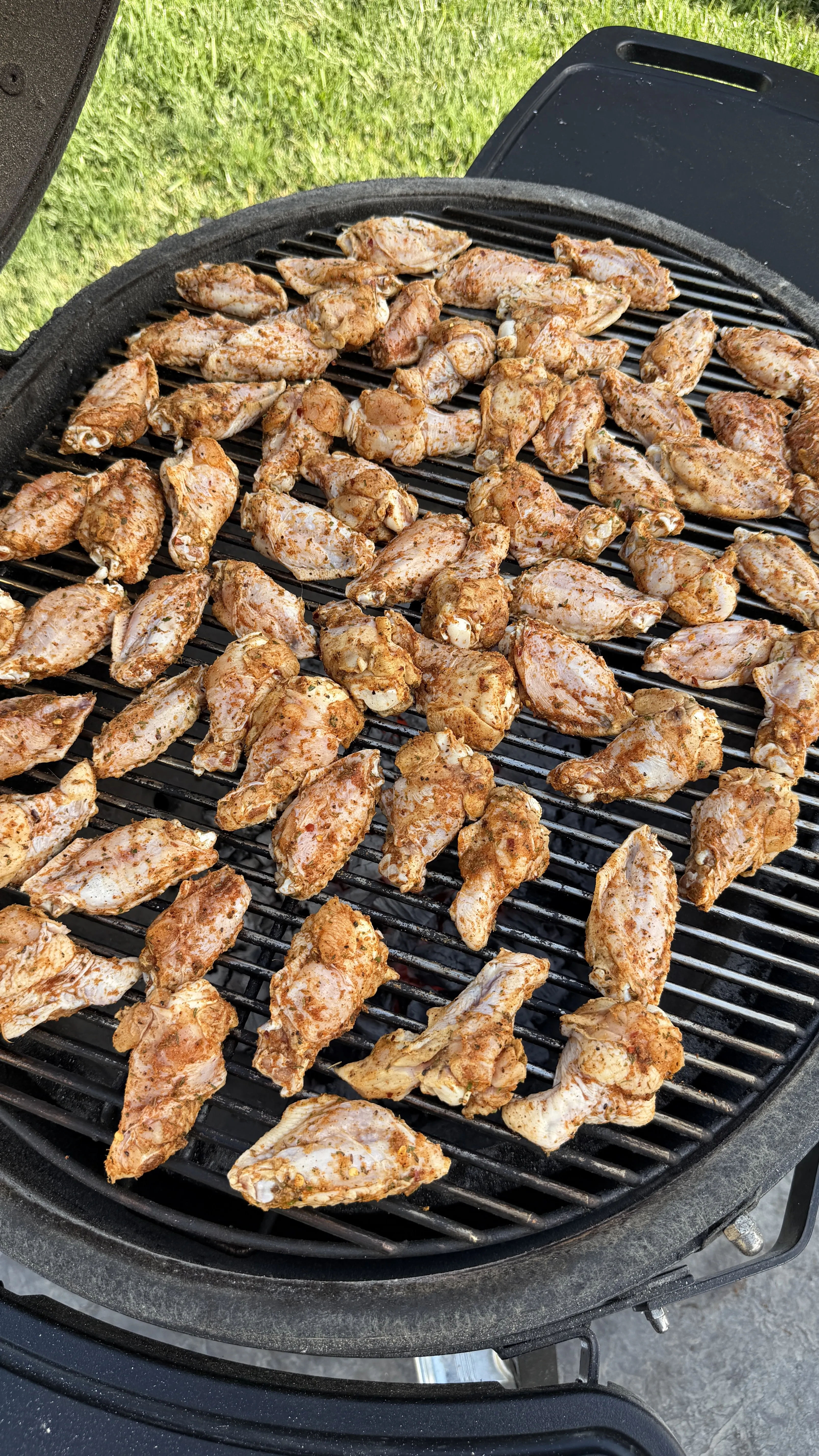 Nashville hot pickle brined chicken wings cooking on a round grill grate with char marks