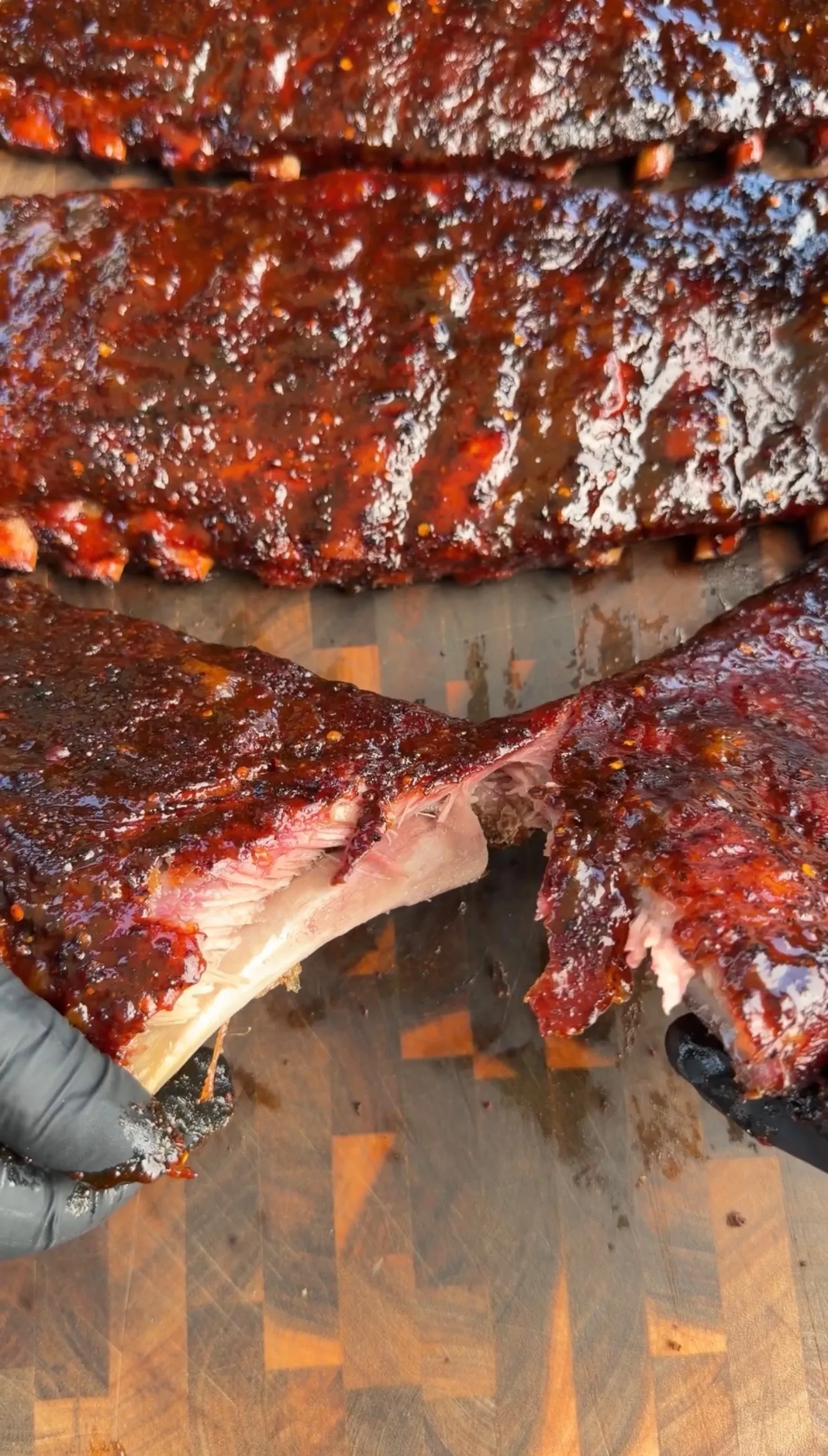 Peach bourbon glazed BBQ ribs sliced on wooden board