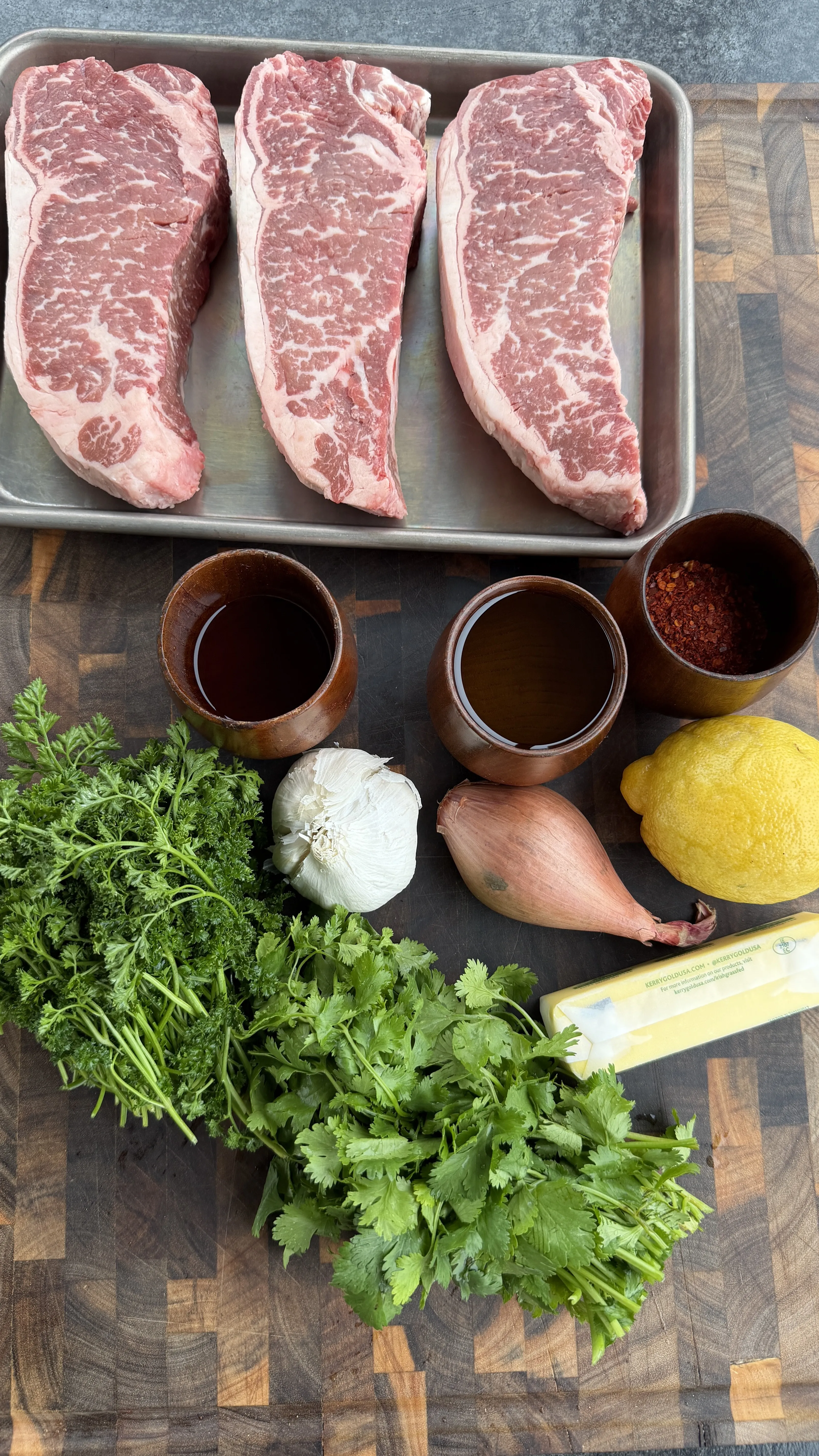 Raw strip steaks and board sauce ingredients