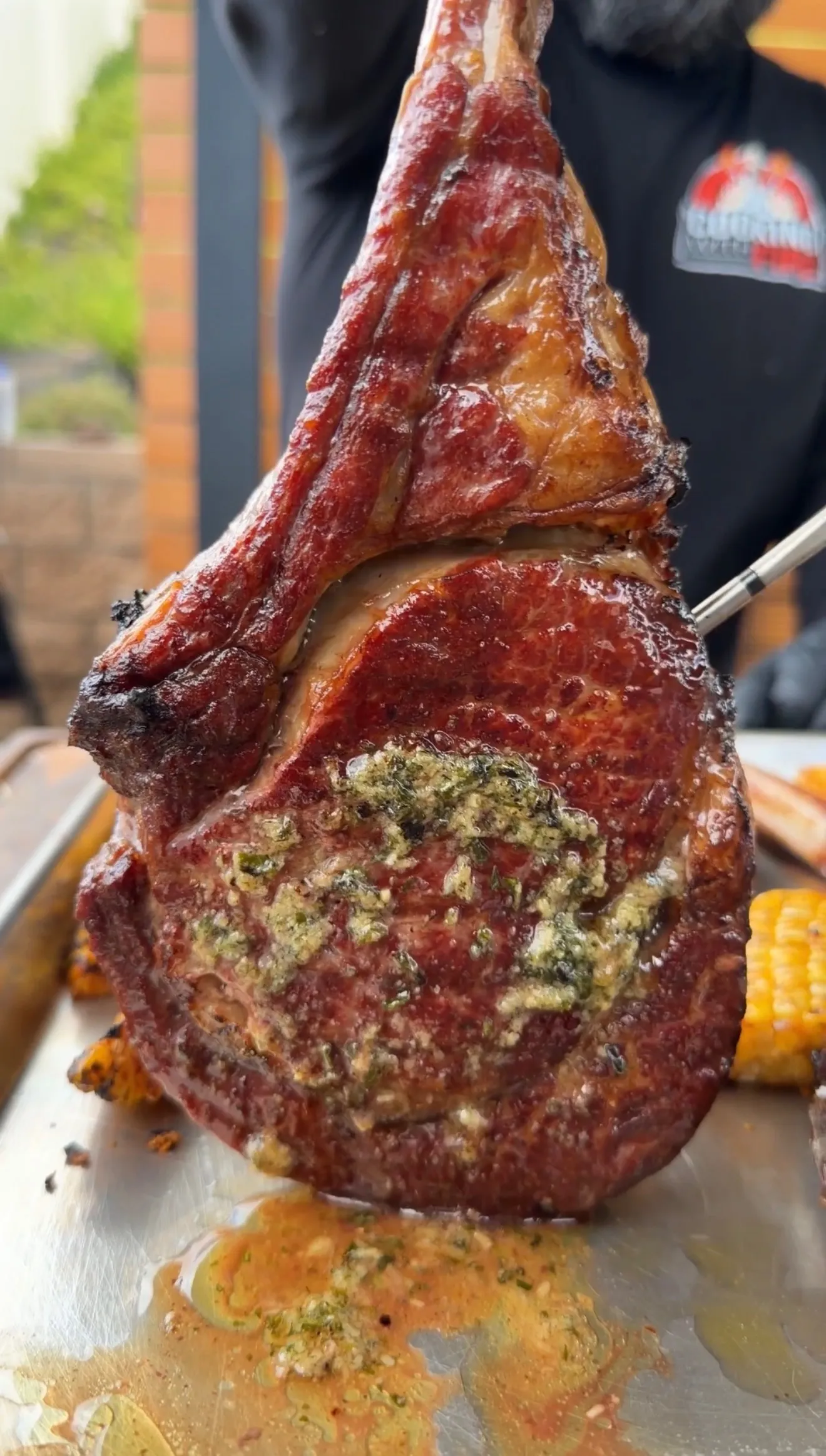 Perfectly seared tomahawk steak with herb crust on salt block, showing beautiful caramelization and garnish