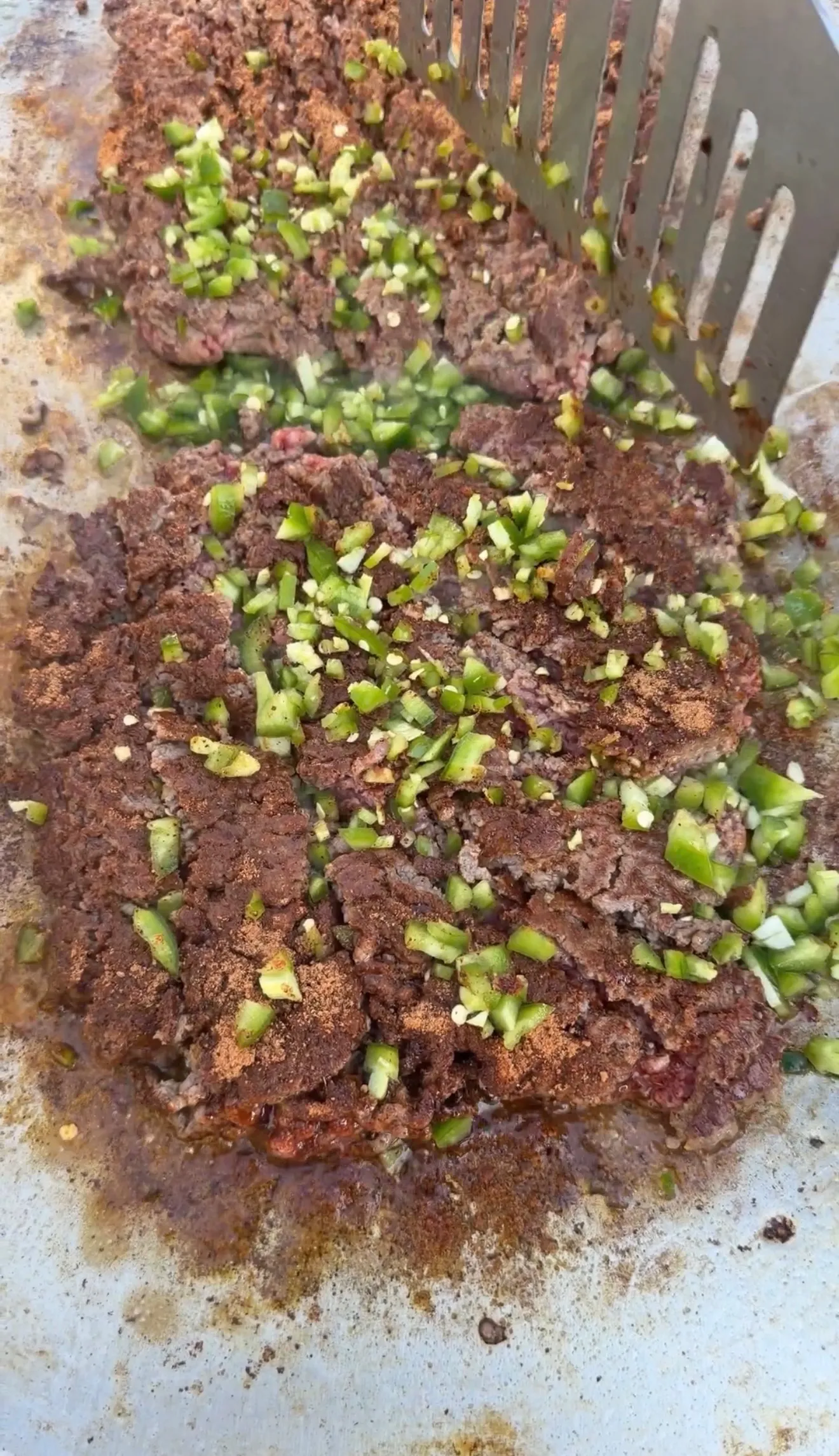 Seasoned ground beef mixture with chopped green onions cooking in a pan for crunchwrap filling
