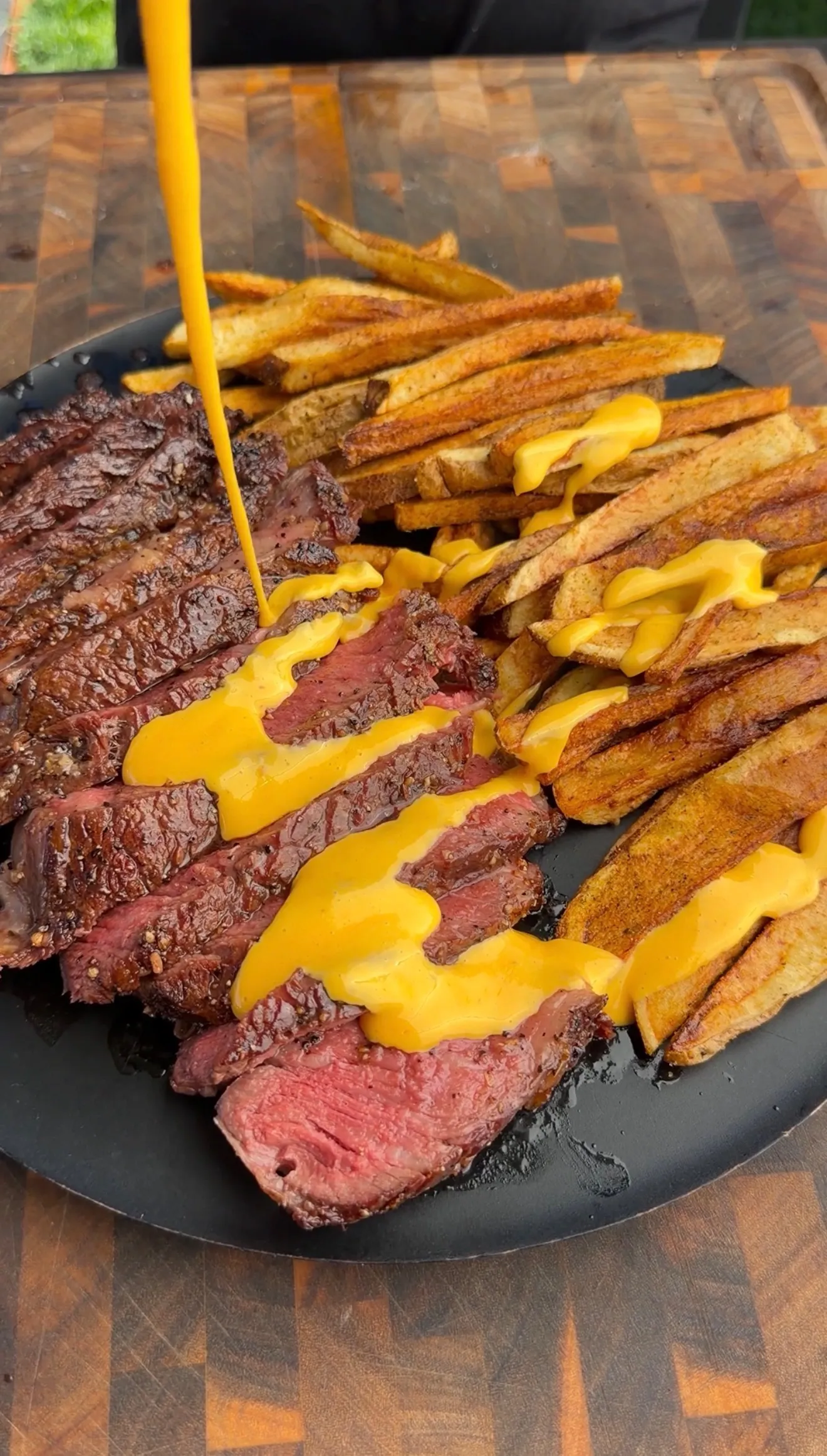 Sliced tomahawk steak with crispy fries and cheese sauce