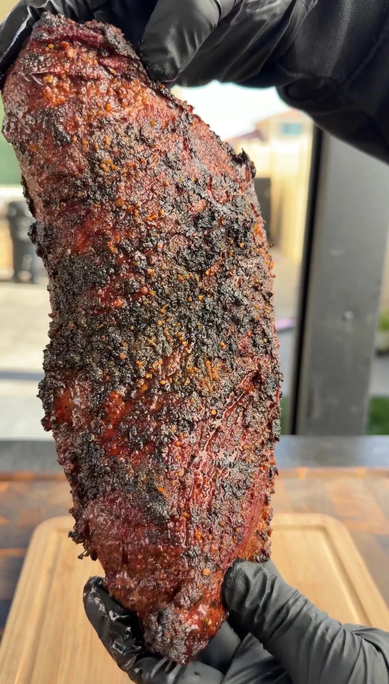 Smoked tri-tip roast with dark bark crust resting after grilling