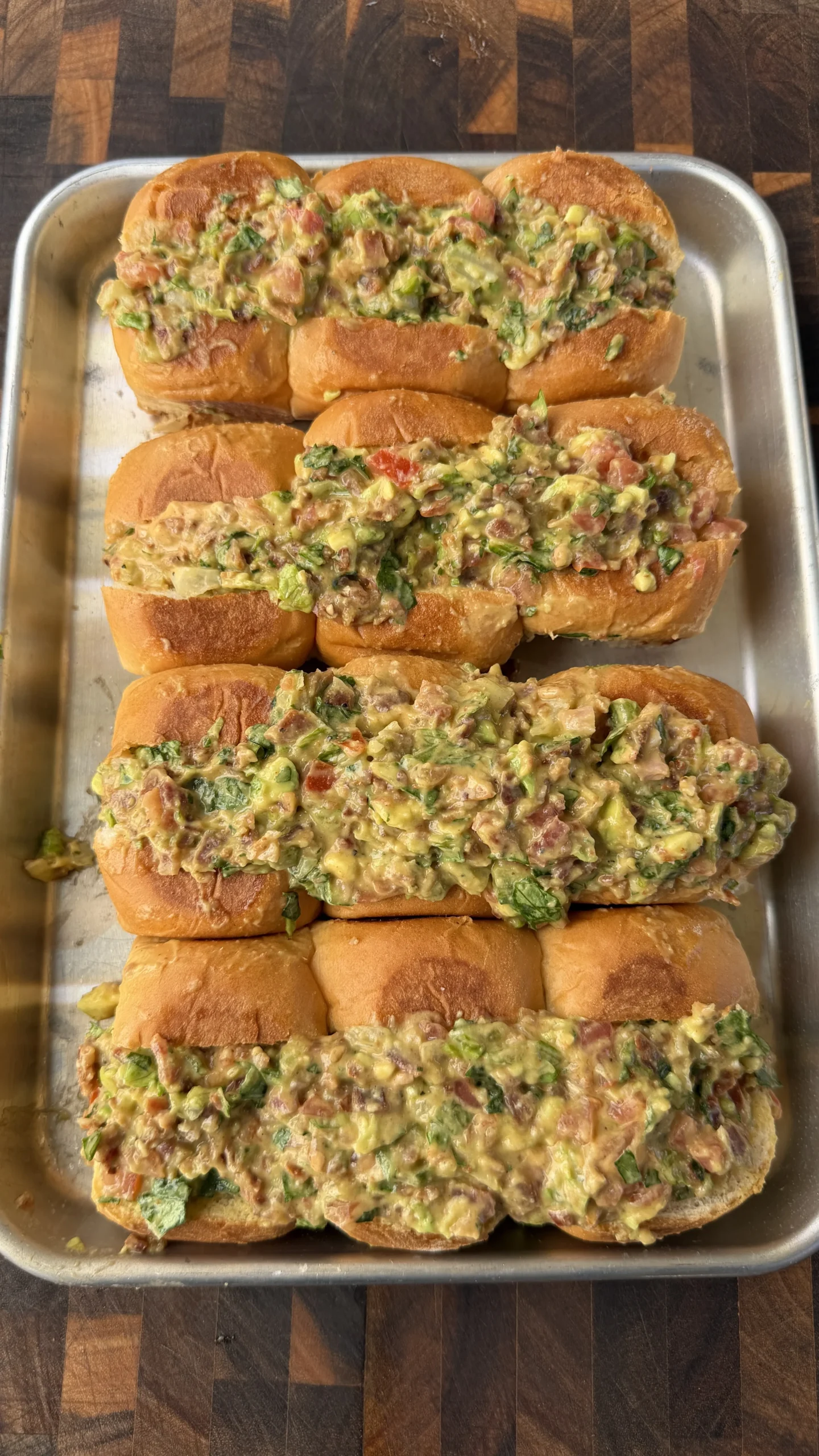 Avocado BLT chopped sliders on a metal tray, topped with chunky avocado bacon tomato filling on brioche rolls