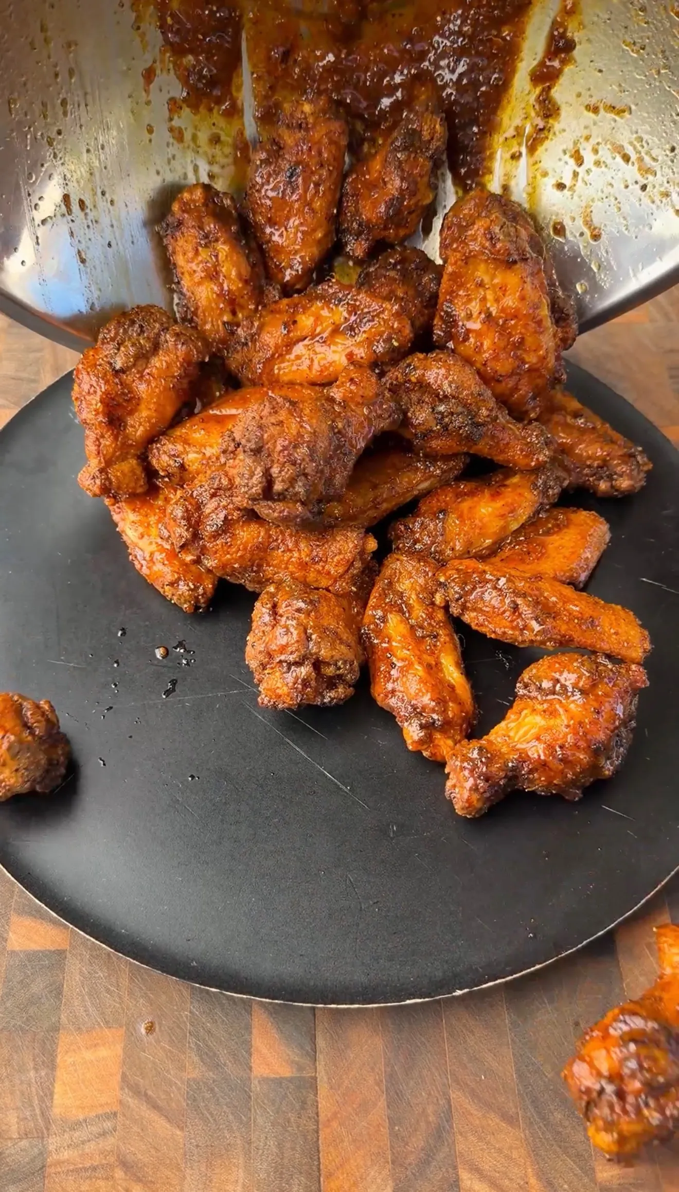 Crispy fried honey lemon pepper chicken wings coated in glossy sauce, piled on a dark round plate