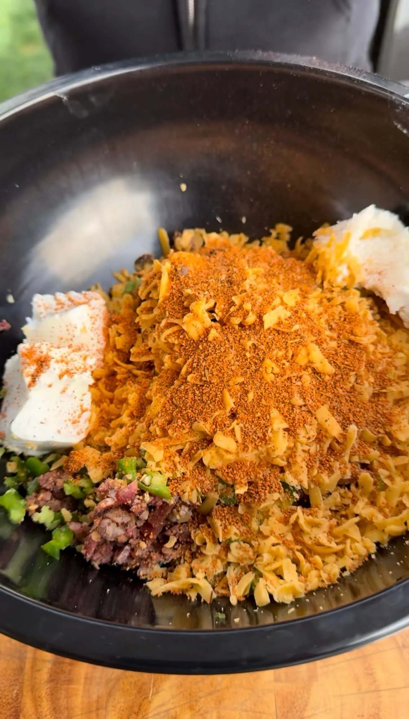 Deep fried jalapeño popper bite mixture with cream cheese, shredded cheese, spices, and jalapeños in a large metal bowl