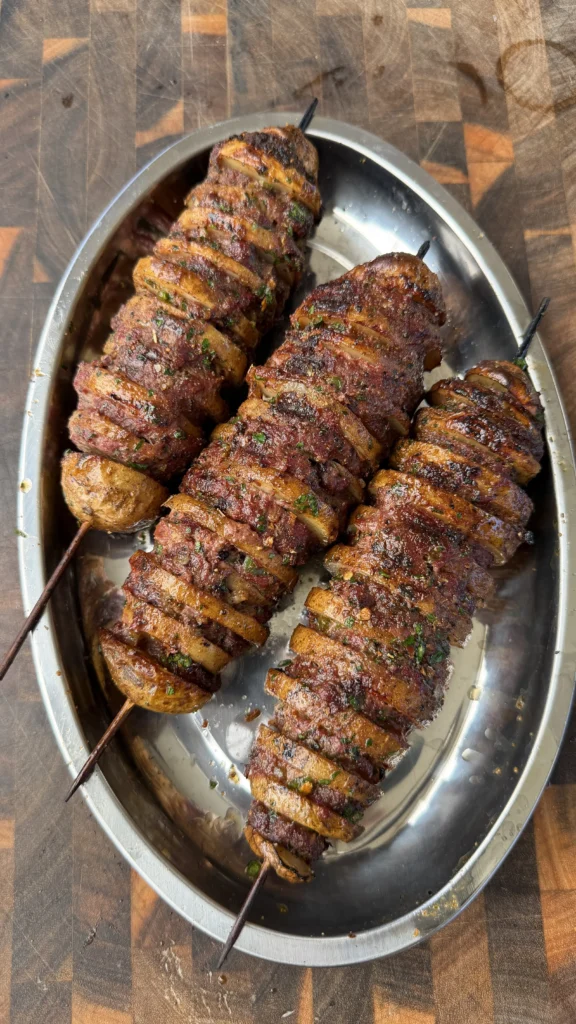 Cajun butter potato beef kebabs on a silver platter, skewered and seasoned with herbs and spices