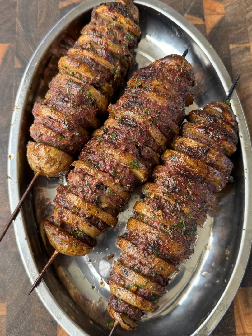 Cajun butter potato beef kebabs on a silver platter, skewered and seasoned with herbs and spices