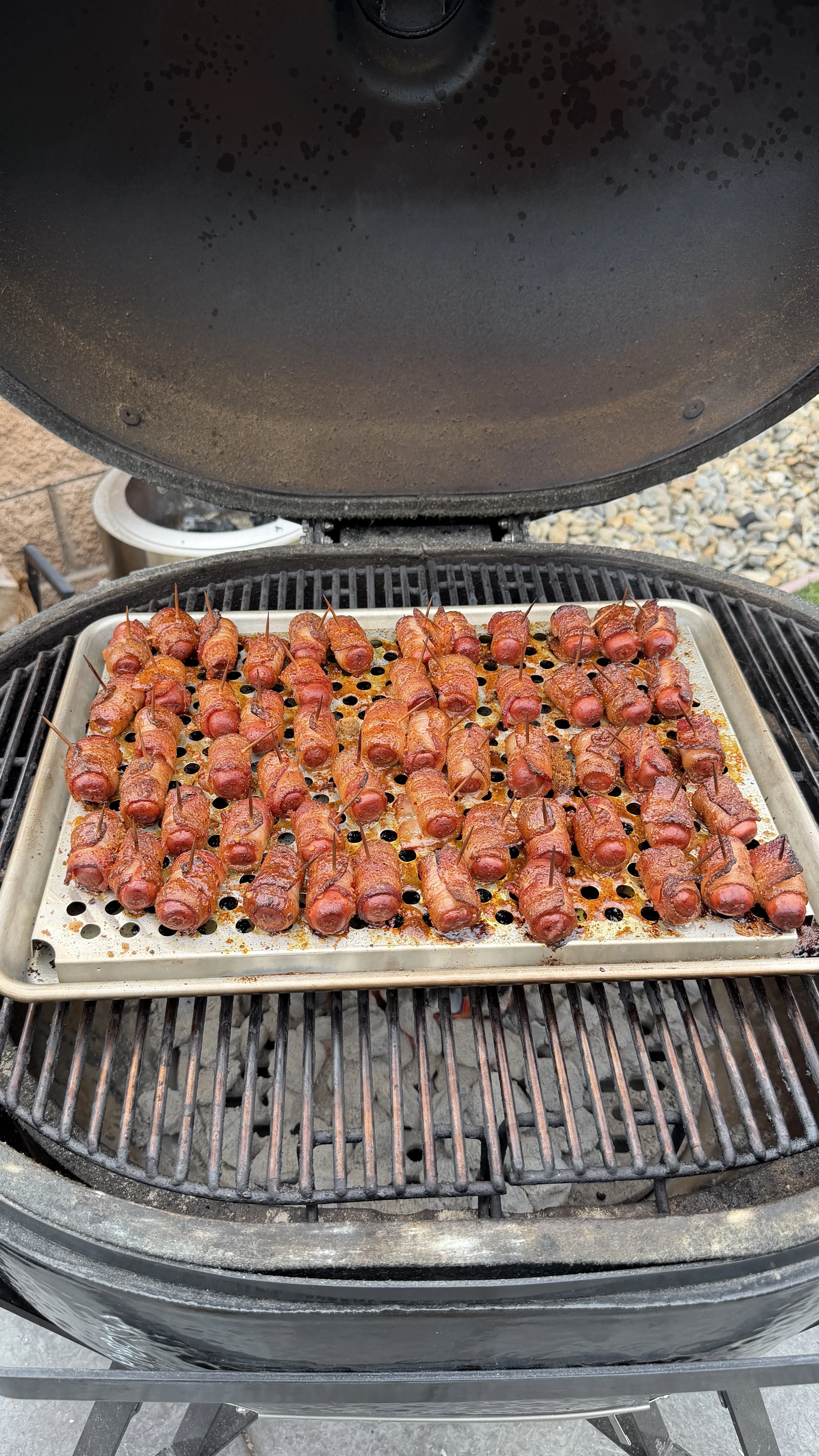 Cajun honey bacon-wrapped little smokies on a smoker grill pan, caramelized and secured with toothpicks