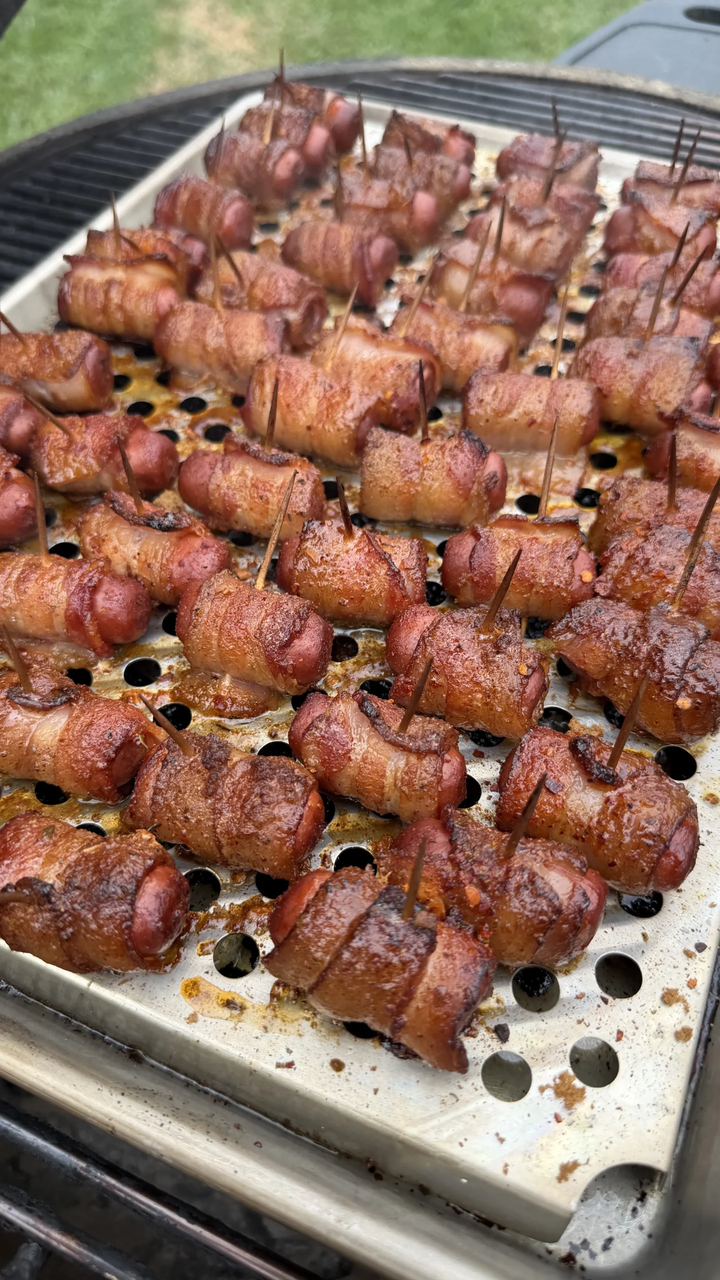 Cajun honey bacon-wrapped little smokies secured with toothpicks, caramelized and smoky on a perforated grill pan