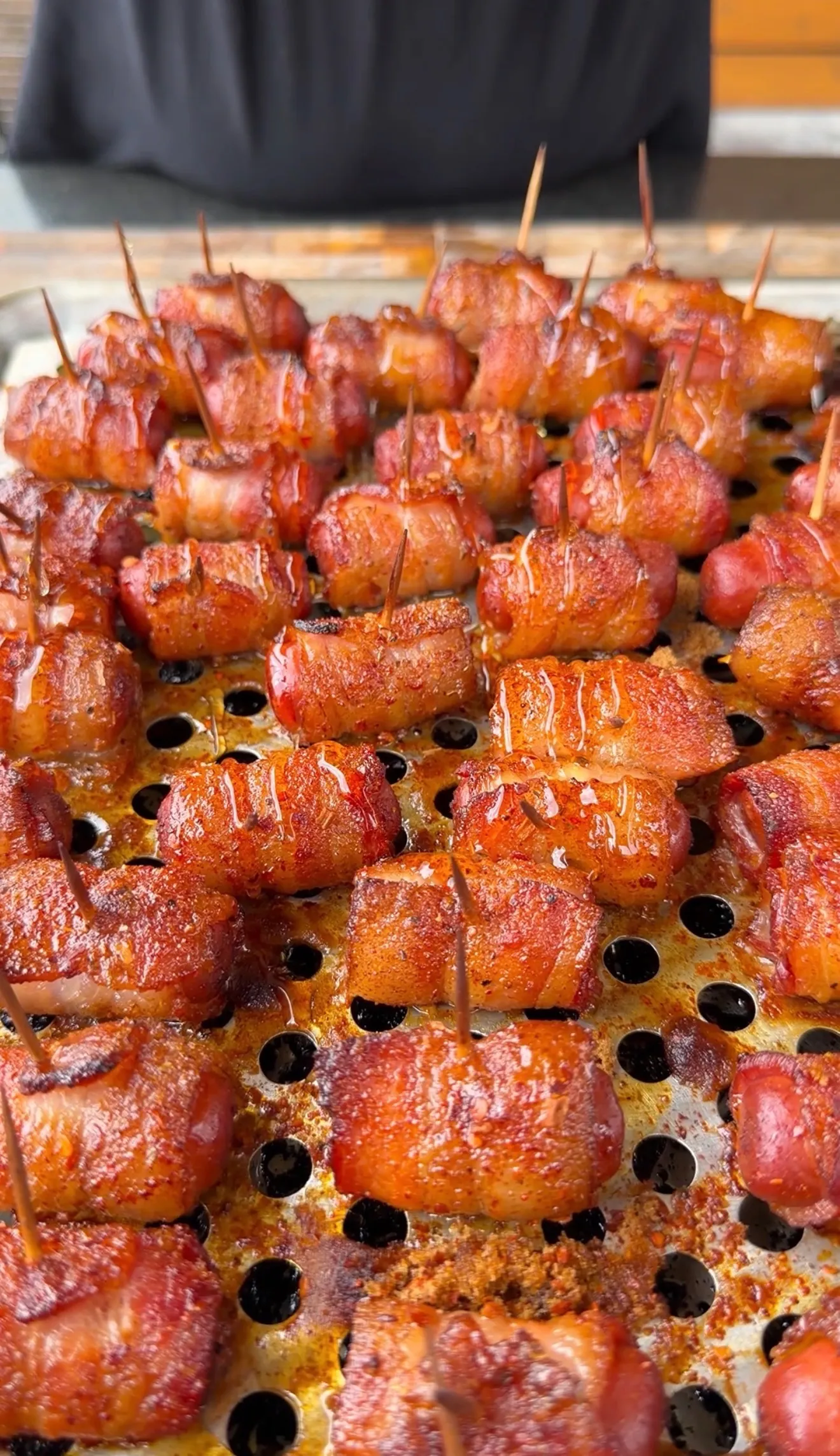 Glazed Cajun honey bacon-wrapped little smokies on a baking pan, secured with toothpicks and caramelized to perfection