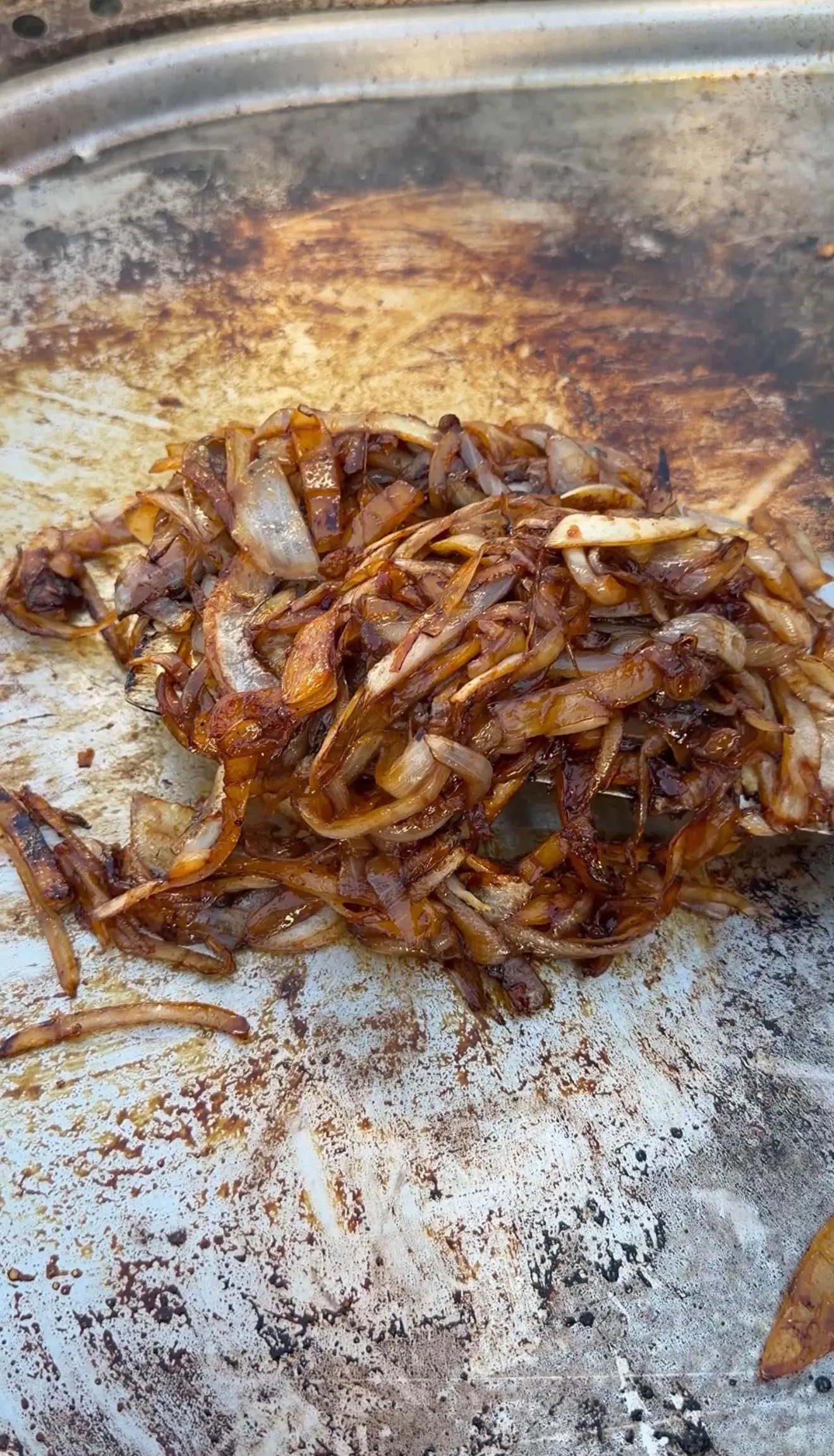 Golden caramelized onions cooked on a well-seasoned griddle for croissant burgers