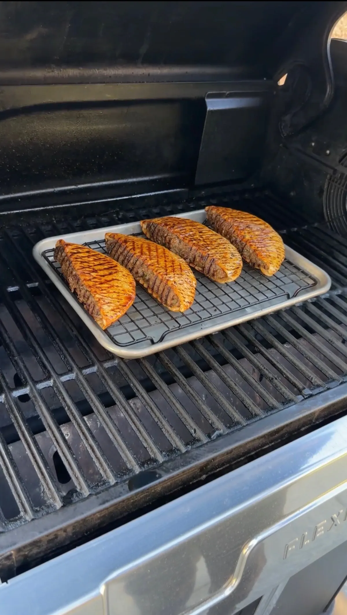 Four stuffed arayes brushed with smoked paprika oil finishing on a gas grill at 300°F on a wire rack