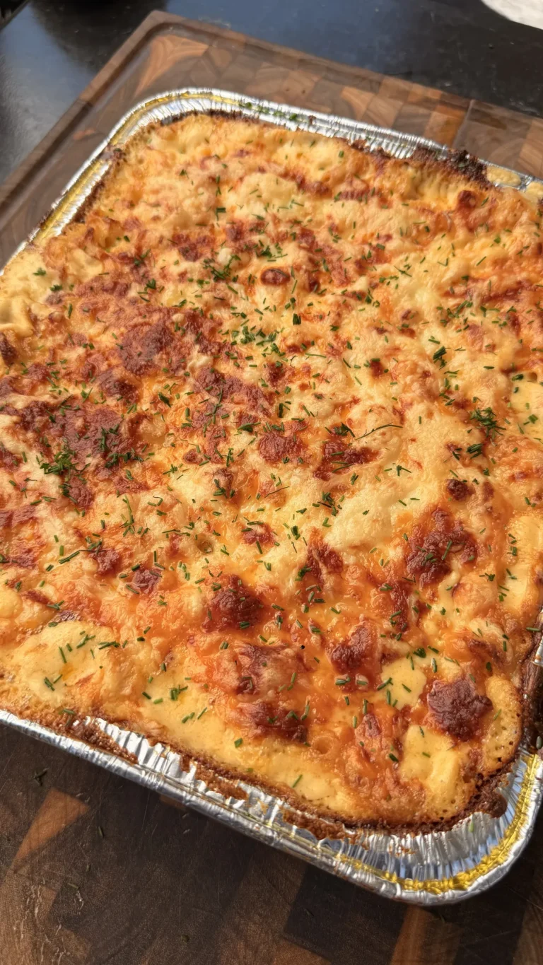 Creamy baked mac and cheese with golden brown crispy top, elbow macaroni, mozzarella, Colby Jack, cheddar, topped with fresh chives