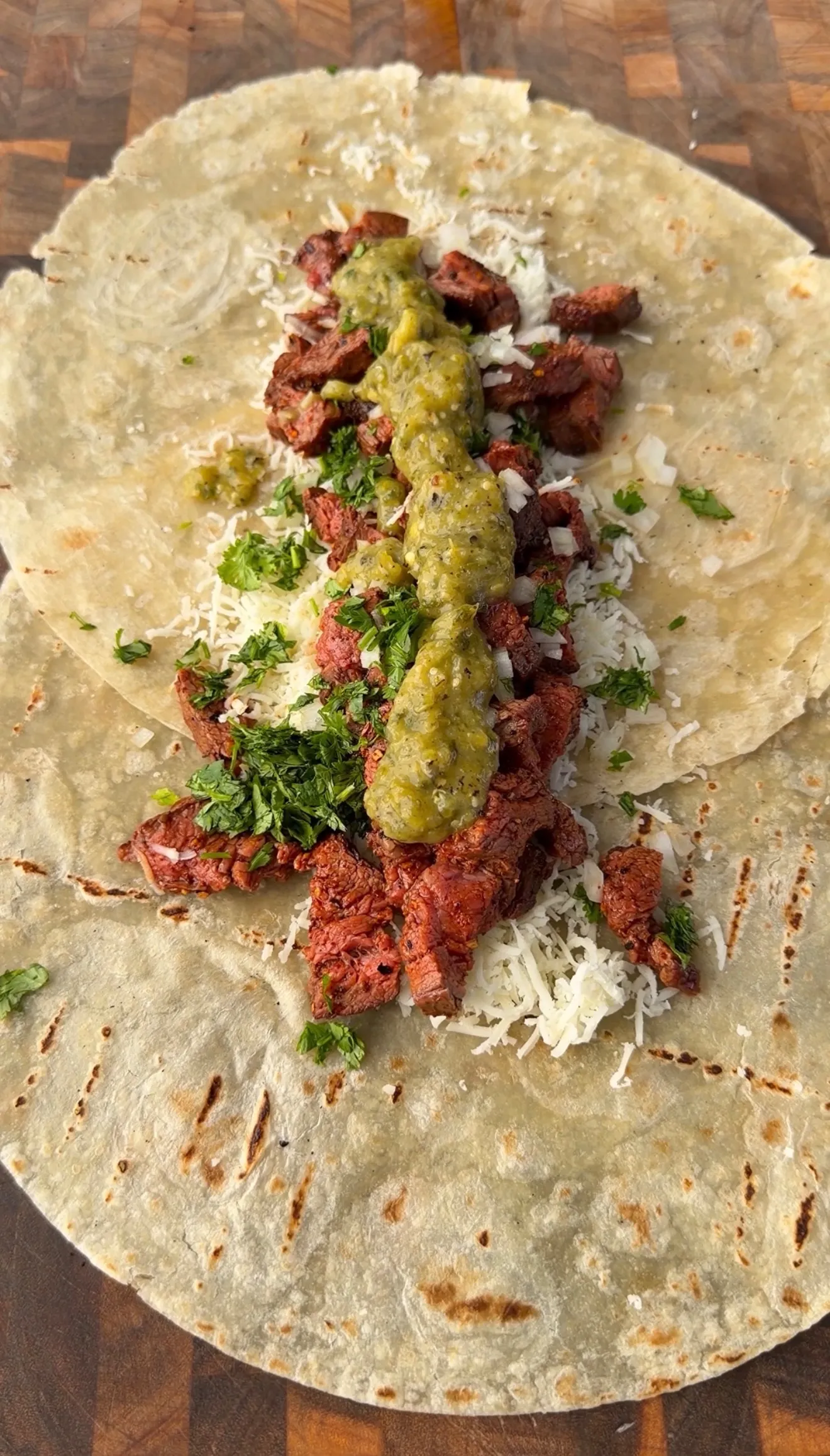 Crispy carne asada chimichanga filling with grilled beef, salsa verde, cilantro, onion, and cheese on flour tortilla