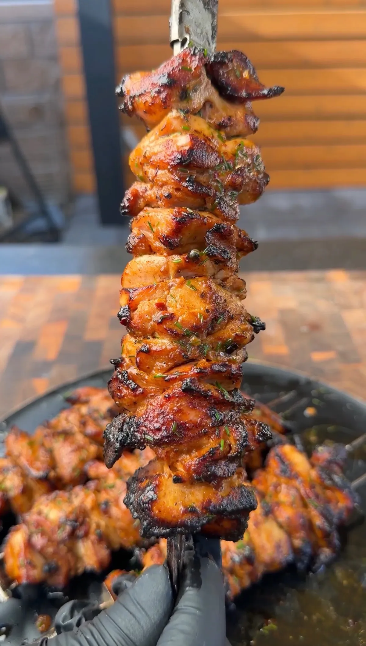 Grilled chili-lime chicken thigh skewers with sticky glaze, charred edges, and fresh cilantro on a dark platter