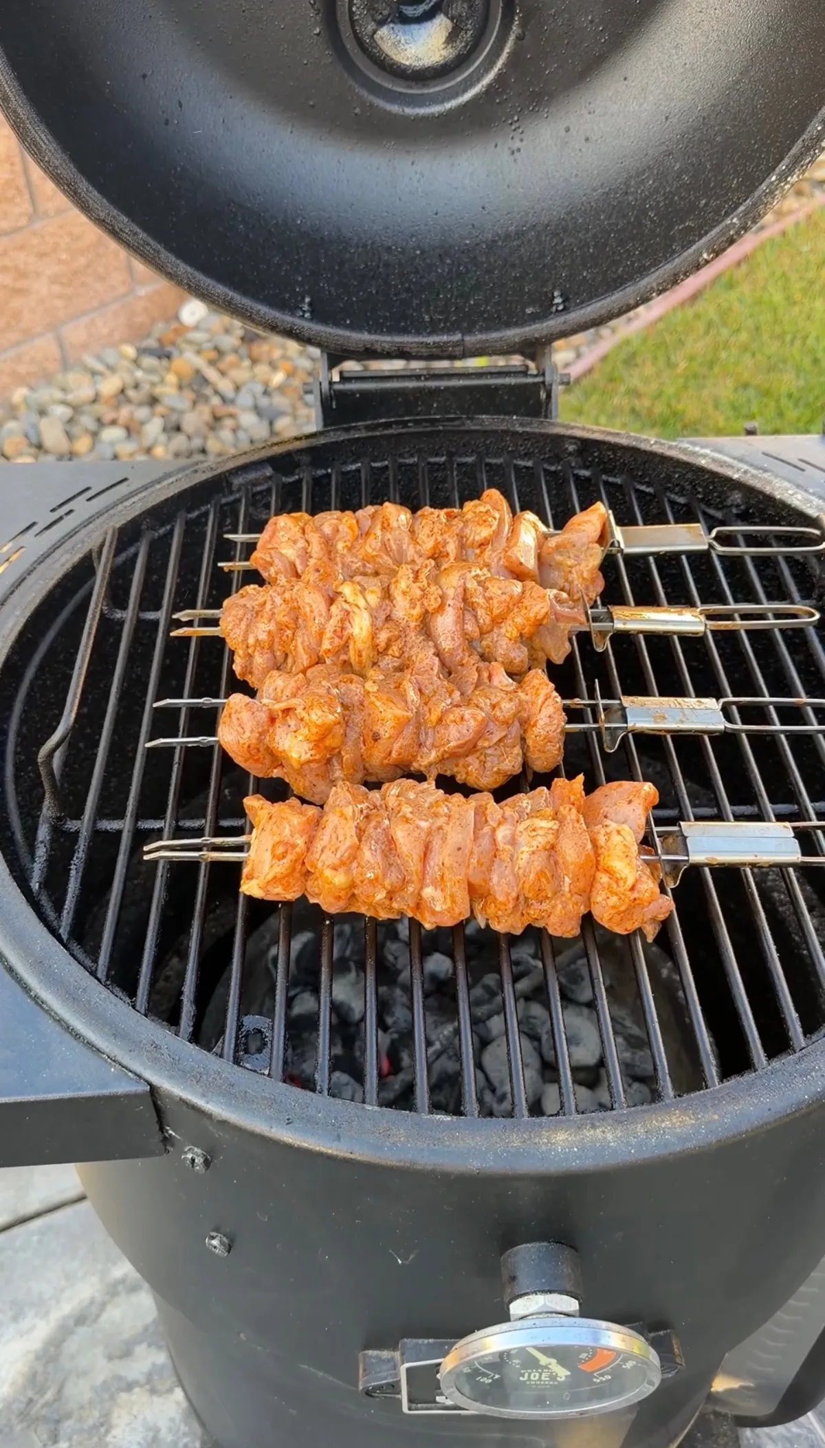 Chili-lime marinated chicken thigh skewers on a charcoal grill at 350°F, ready to cook