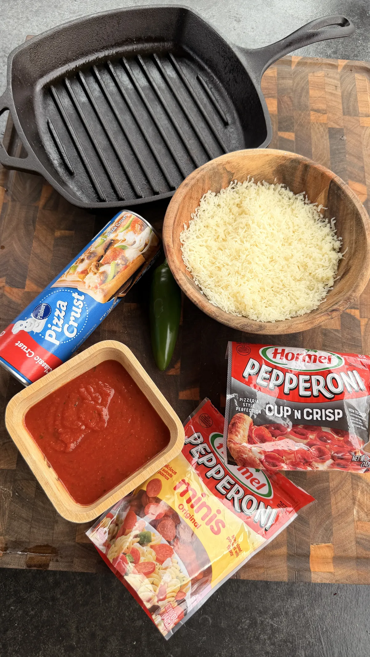 Ingredients for upside-down deep dish jalapeño pepperoni pizza: Pillsbury dough, marinara, mozzarella, Hormel pepperoni, and cast-iron skillets