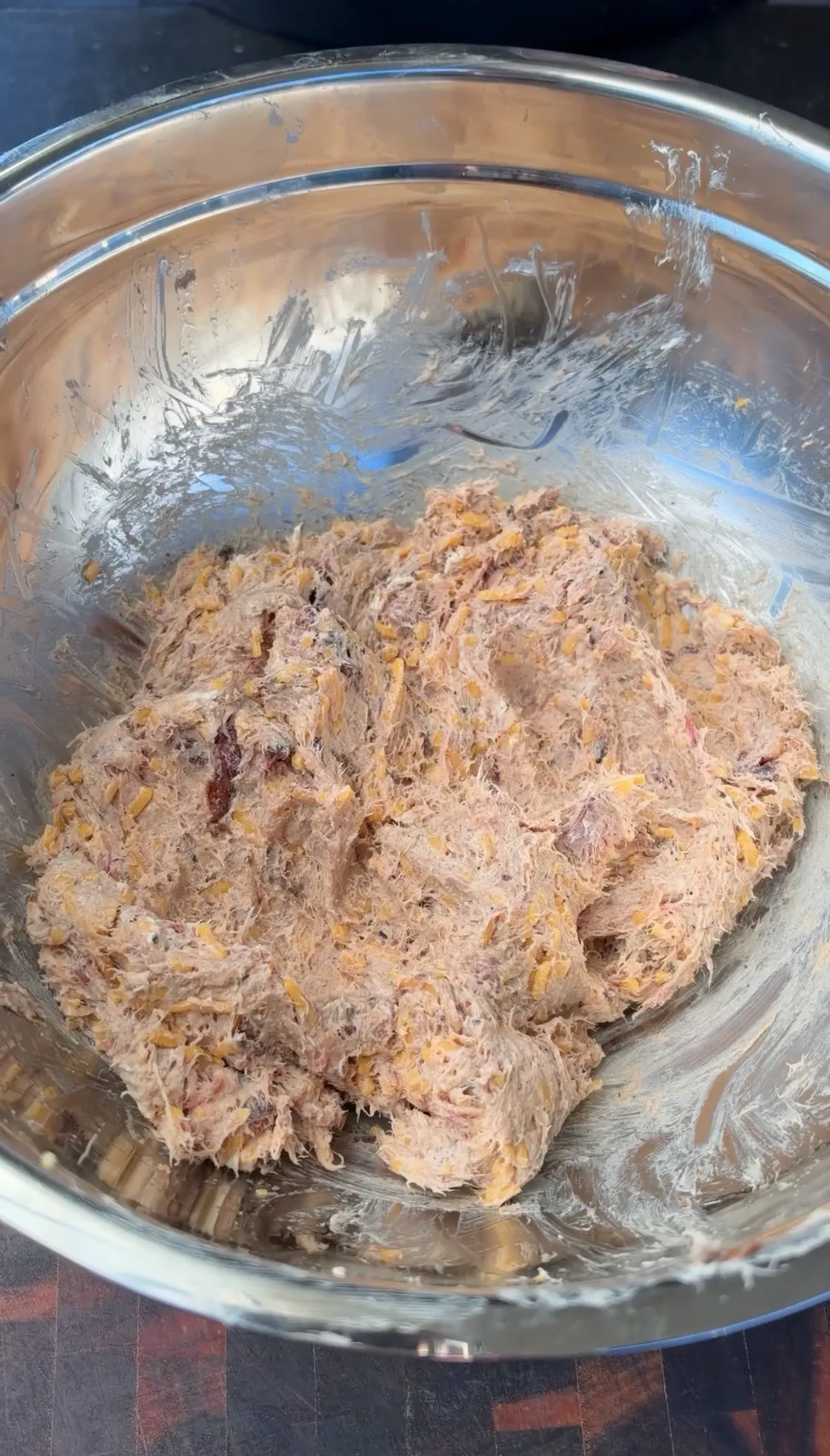 Smoked brisket, cream cheese, shredded cheddar, and BBQ seasoning mixed together in a stainless steel bowl