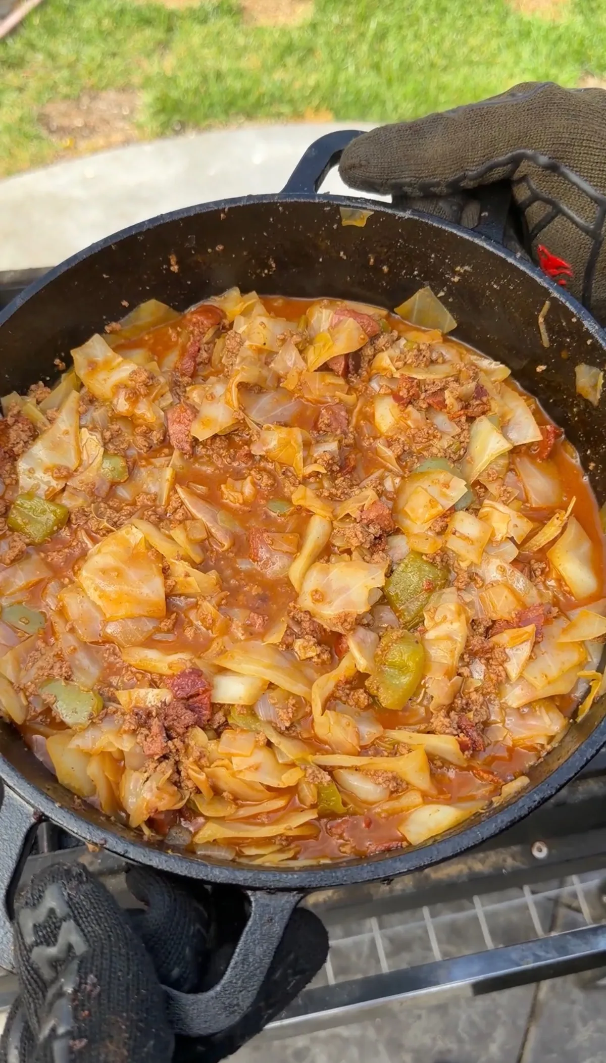 Viral dirty cabbage with ground chuck, kielbasa, bacon, green bell pepper, and onion simmered in Creole-seasoned sauce in a cast iron Dutch oven