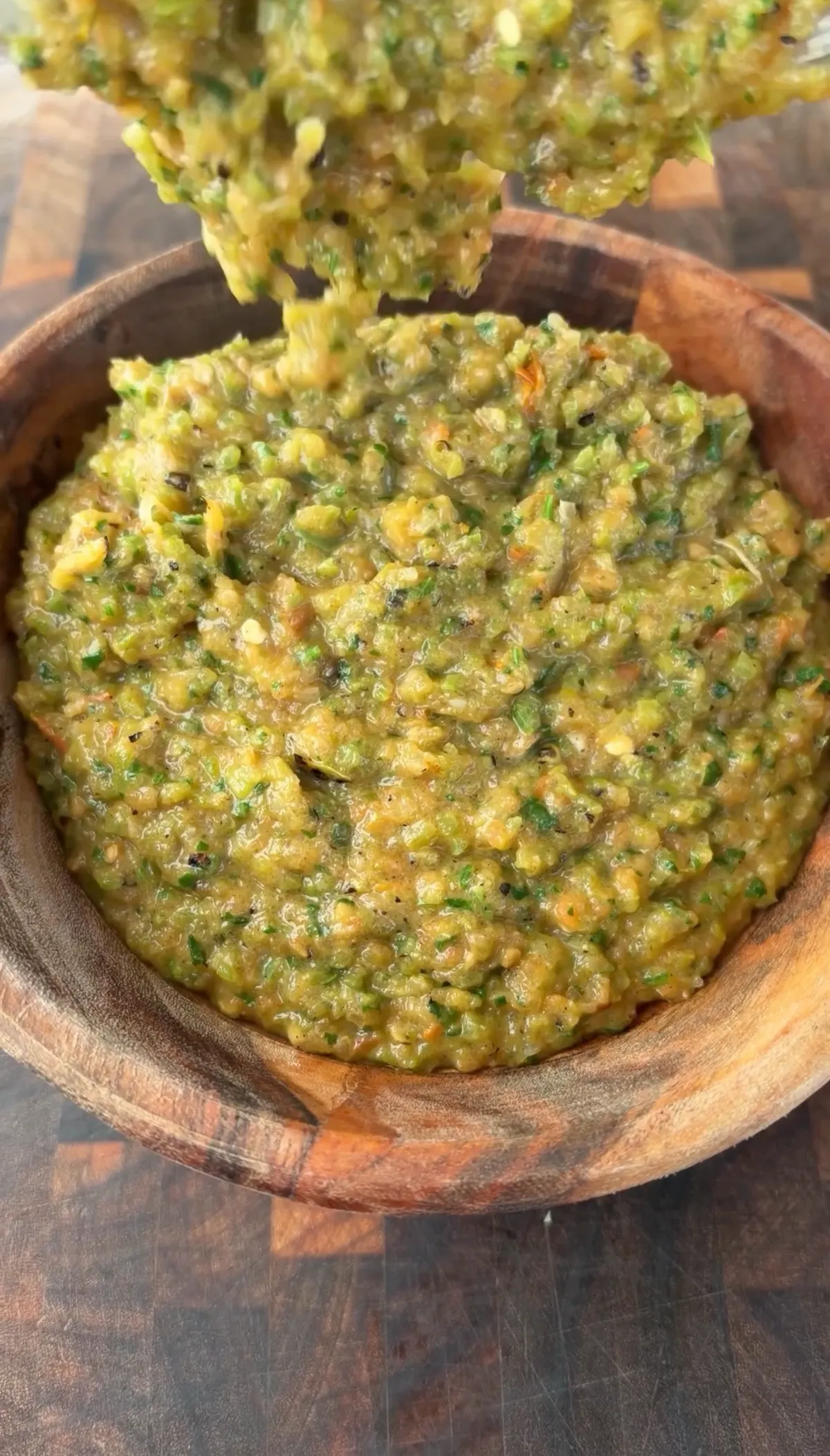 Roasted Hatch chile salsa blended with tomatoes, cilantro, and garlic in a rustic wooden bowl