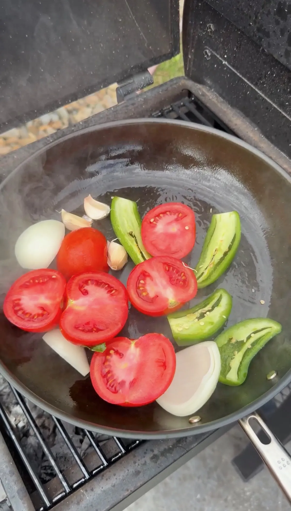Roma tomatoes, jalapeños, white onion, and garlic cut and placed in a pan for roasted salsa