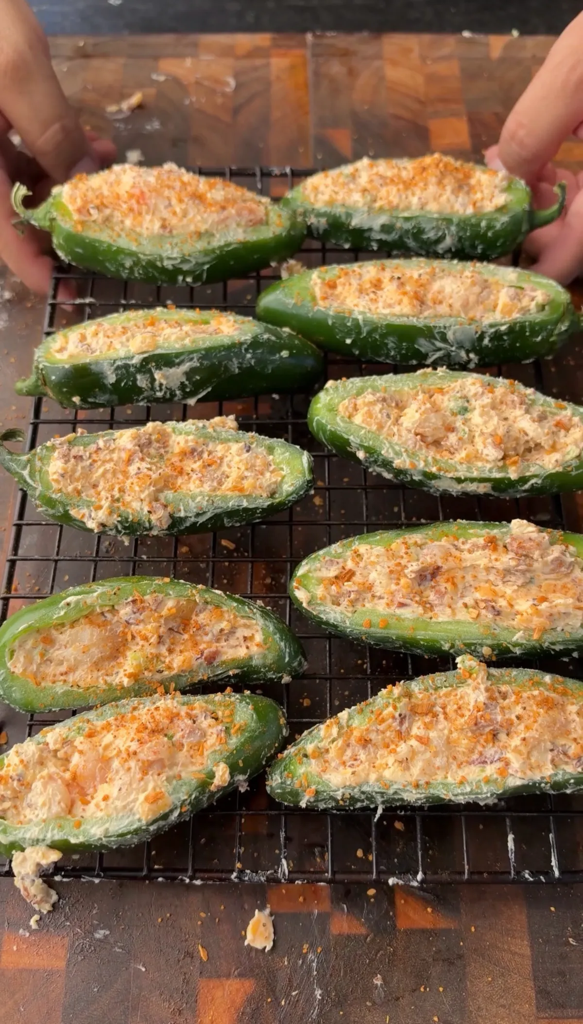Jalapeño boats stuffed with sausage, shrimp, cream cheese, and cheddar filling on a wire rack, ready to smoke over Applewood