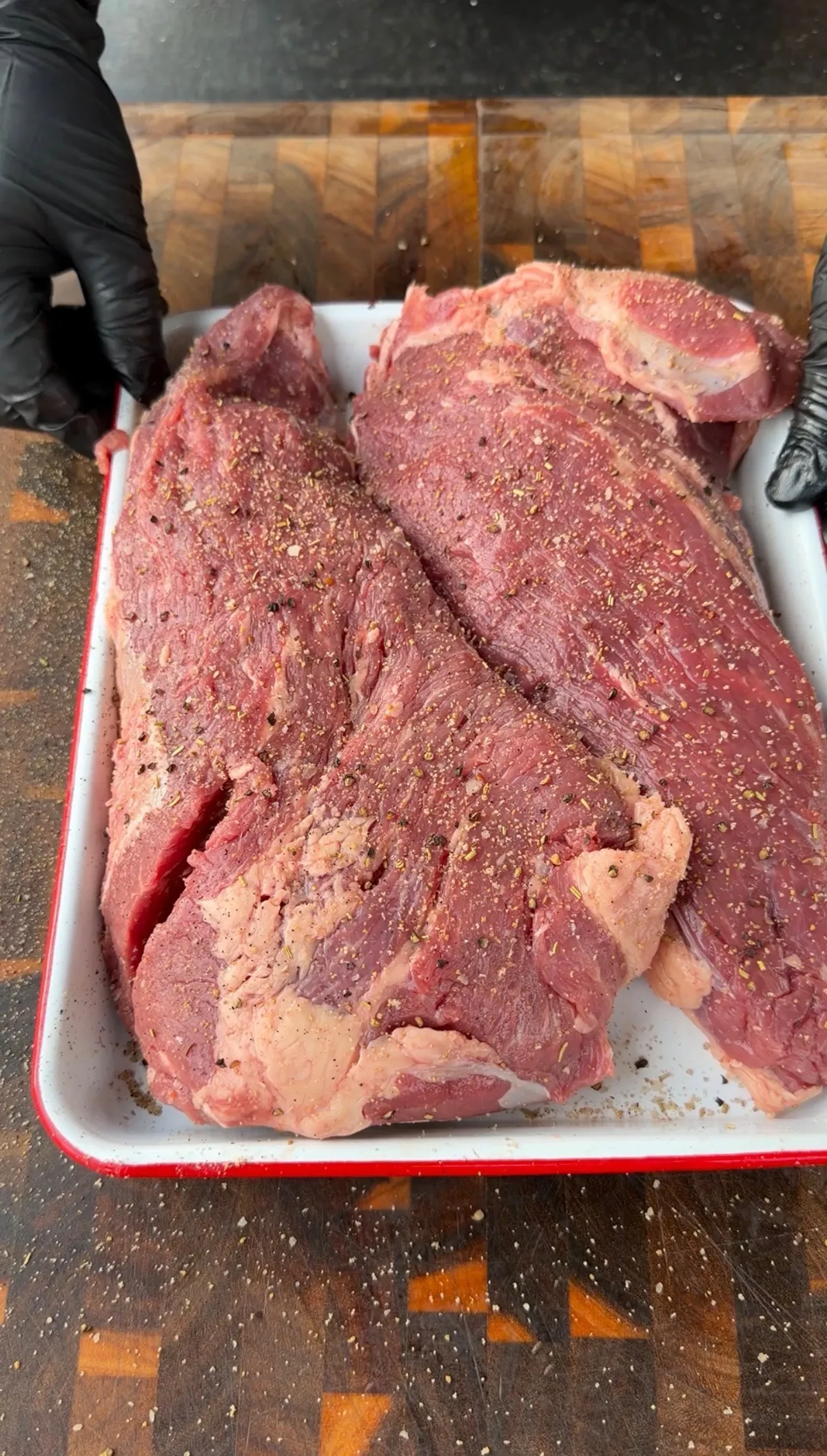 Whole tri-tip generously seasoned with steak seasoning on a white tray, fat cap intact, ready to smoke at 250°F