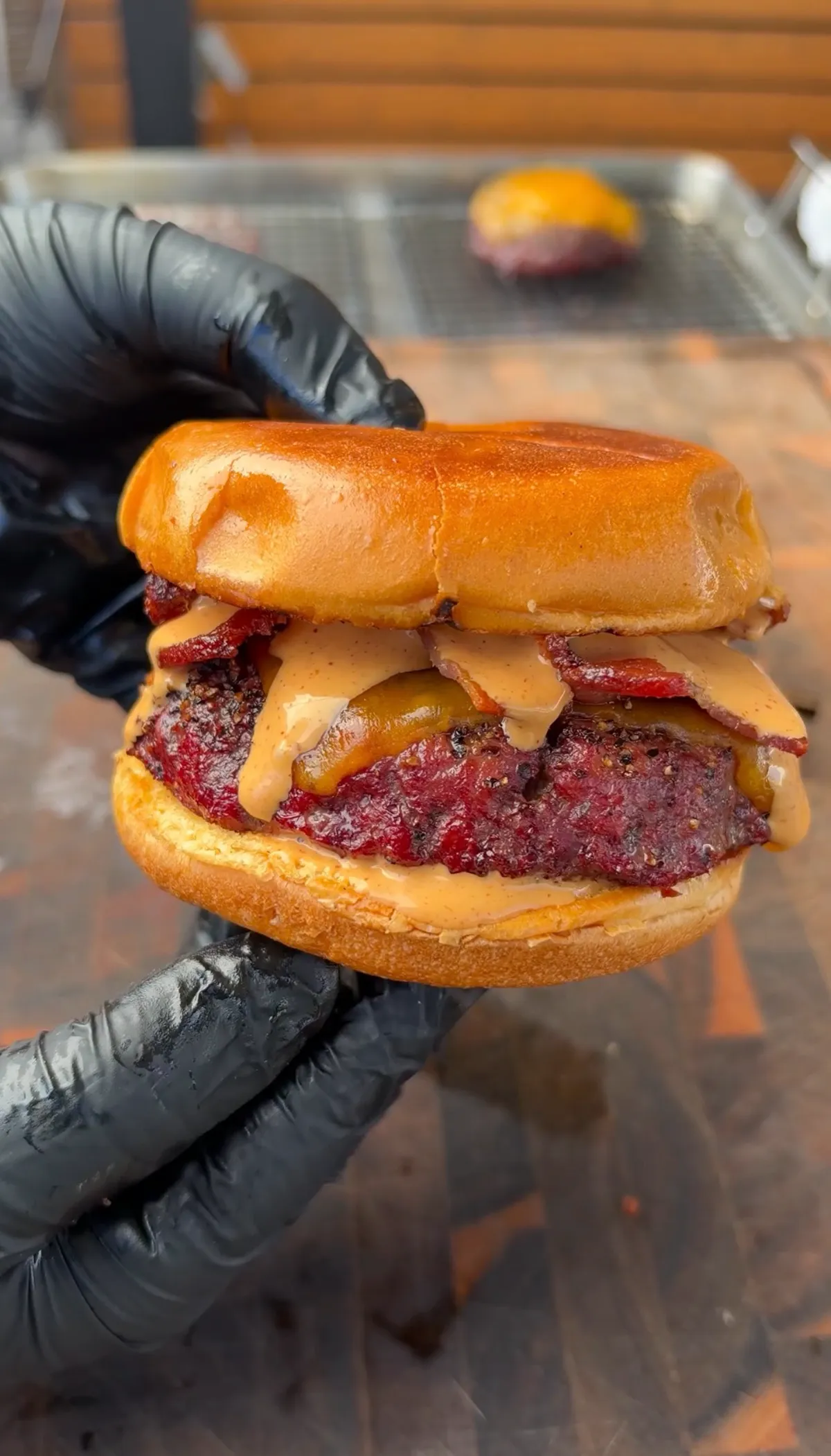 Smoked beer can burger with chipotle mayo, crispy bacon, and melted cheddar on a toasted brioche bun