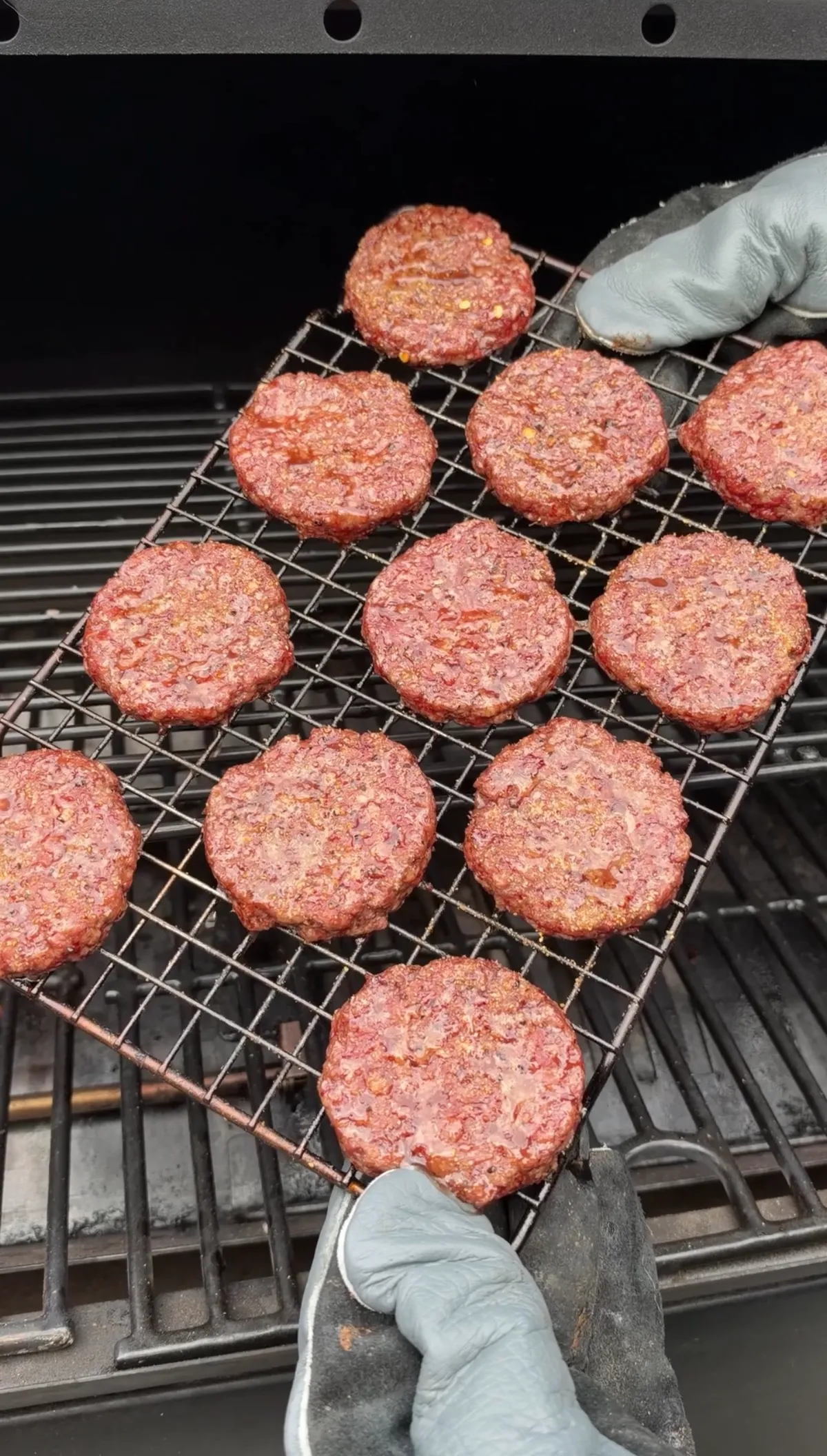Mini 85/15 ground beef patties seasoned with Bear Mountain Barbecue Tailgating Blend on a wire rack over a pellet smoker at 250°F