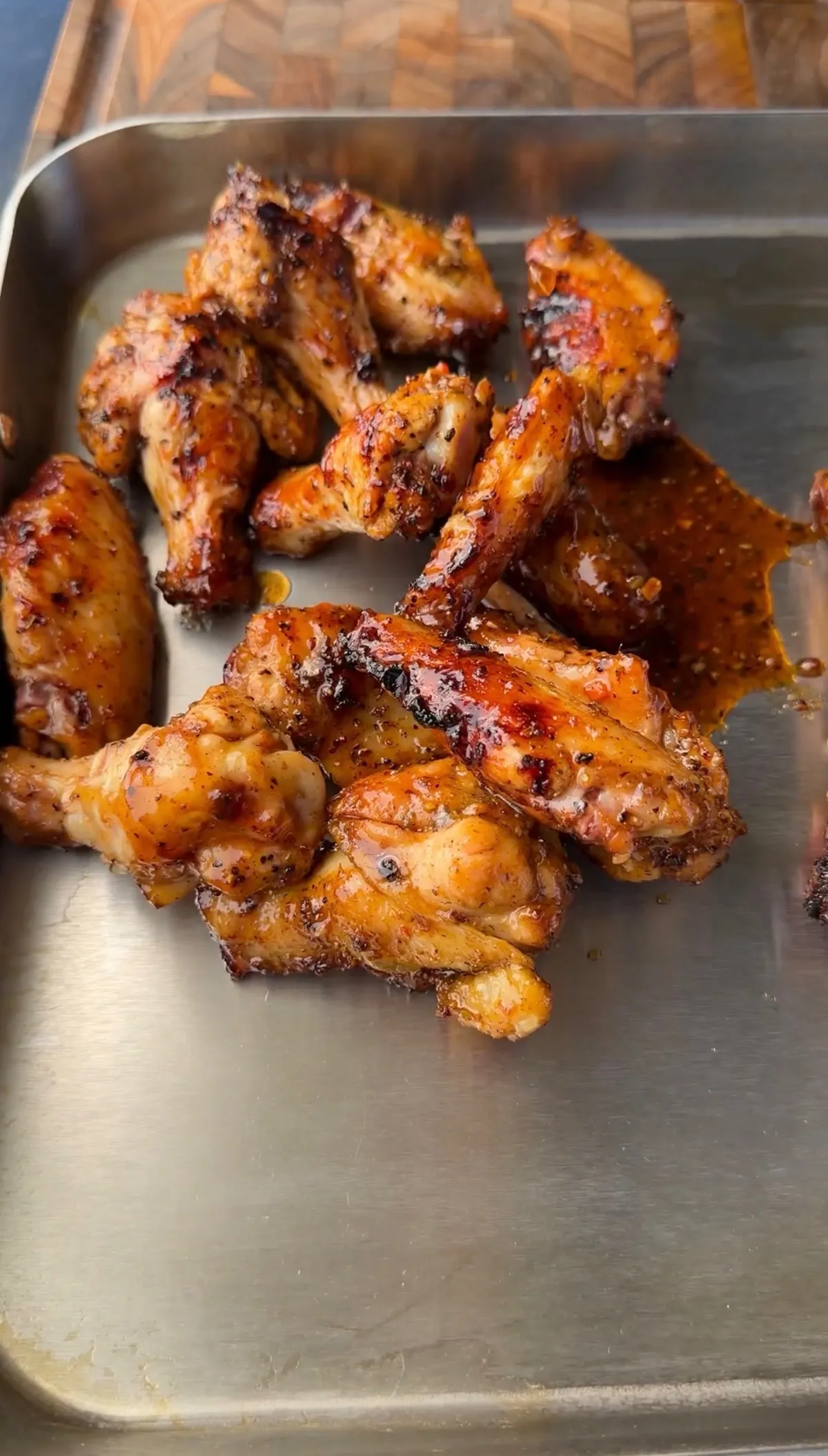 Grilled three-way chicken wings with jalapeño honey butter, honey lemon pepper, and Cajun dry rub on a stainless steel tray