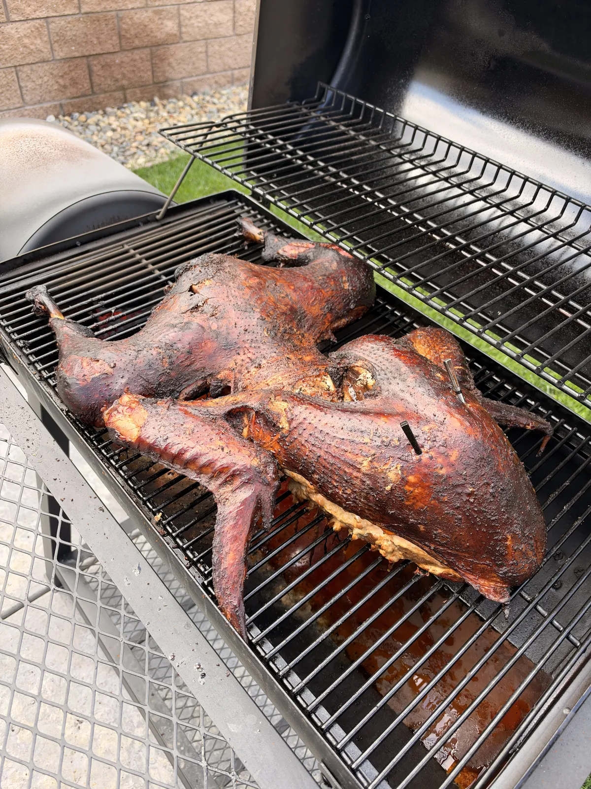 Cajun injected turkey prepared frog-style, flattened on smoker grates with deeply seasoned, darkened skin