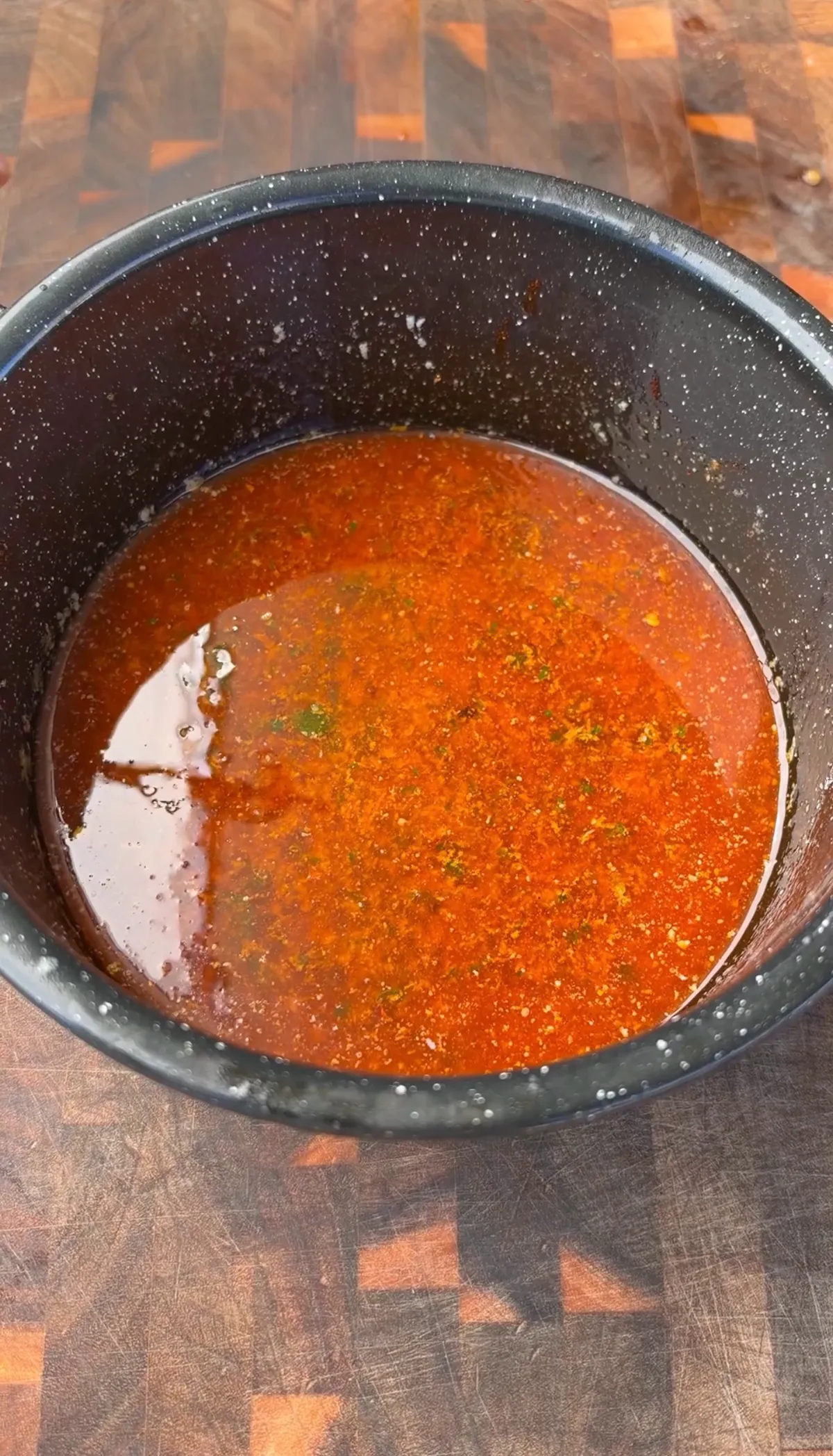Warm cowboy butter with paprika, parsley, lemon zest, and red pepper flakes in a dark saucepan