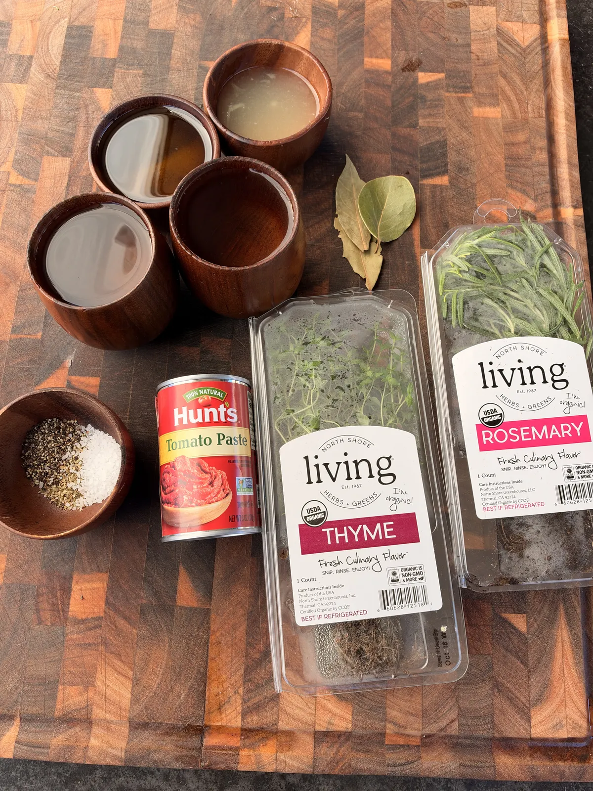 Braising liquid ingredients for Greek lamb: Hunt's tomato paste, beef broth, white wine, fresh thyme, rosemary, and bay leaves