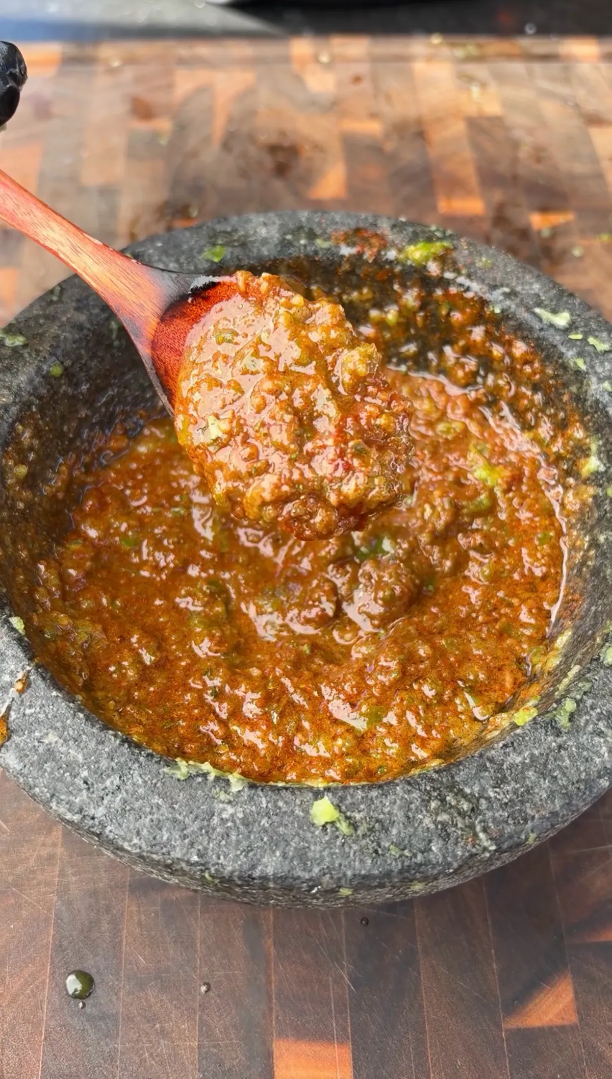 Smoky green chile, garlic, chipotle, and smoked paprika marinade blended in a stone mortar and pestle with a wooden spoon