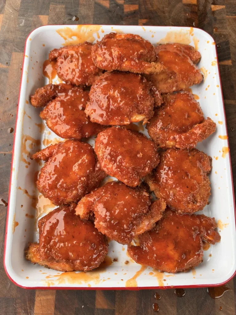 Crispy panko-breaded fried shrimp brushed with hot honey buffalo sauce on a white serving platter