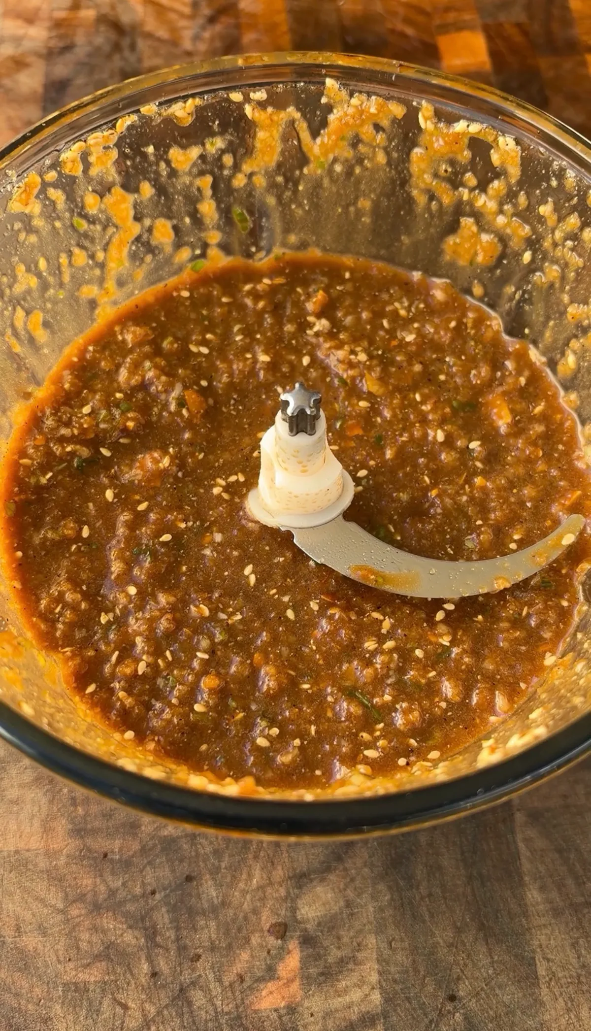 Blended Korean kalbi marinade with soy sauce, sesame seeds, and Asian pear in a food processor bowl