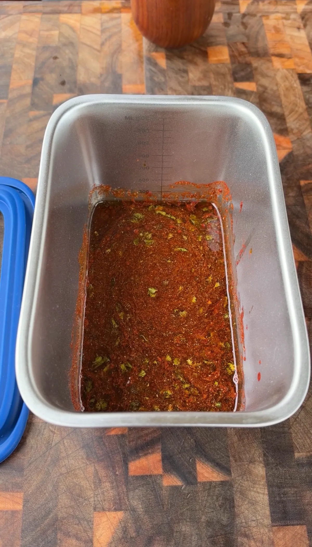 Skirt steak submerged in citrus fajita marinade with smoked paprika, oregano, and lime juice in a sealed container