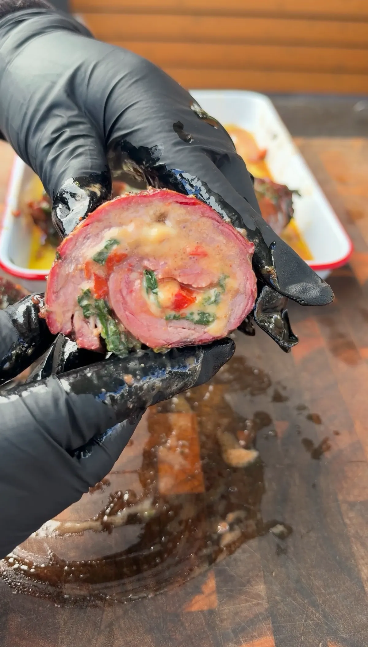 Sliced skirt steak stuffed pinwheel showing creamy spinach, roasted red bell peppers, and melted Colby Jack cheese filling