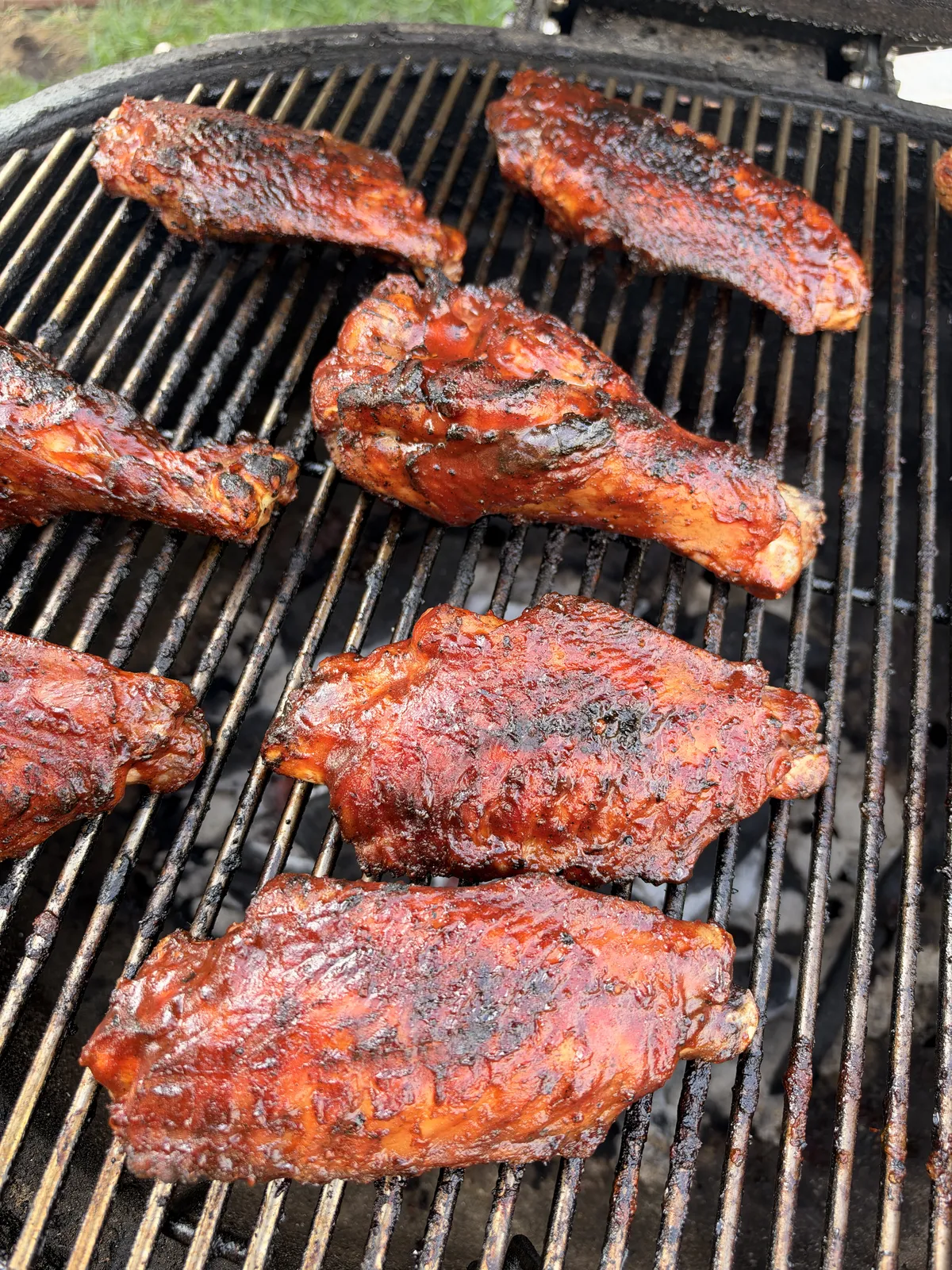 BBQ-glazed turkey wing drumettes and flats caramelizing on grill grates at 350°F